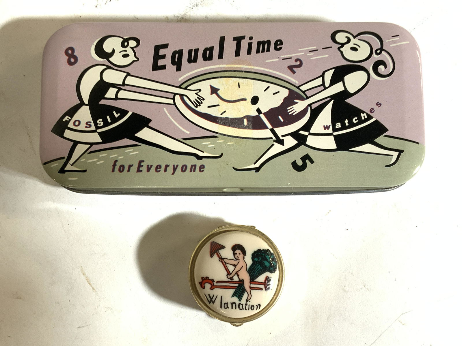Lot 2 Vintage Metal Trinket Boxes: Lot includes 2 trinket boxes. Each piece is vintage. Larger box reads EQUAL TIME FOR EVERYONE, underside reads TIMELY FOSSIL WATCHES. Top of larger box depicts 2 female figure holding a clock. Smaller