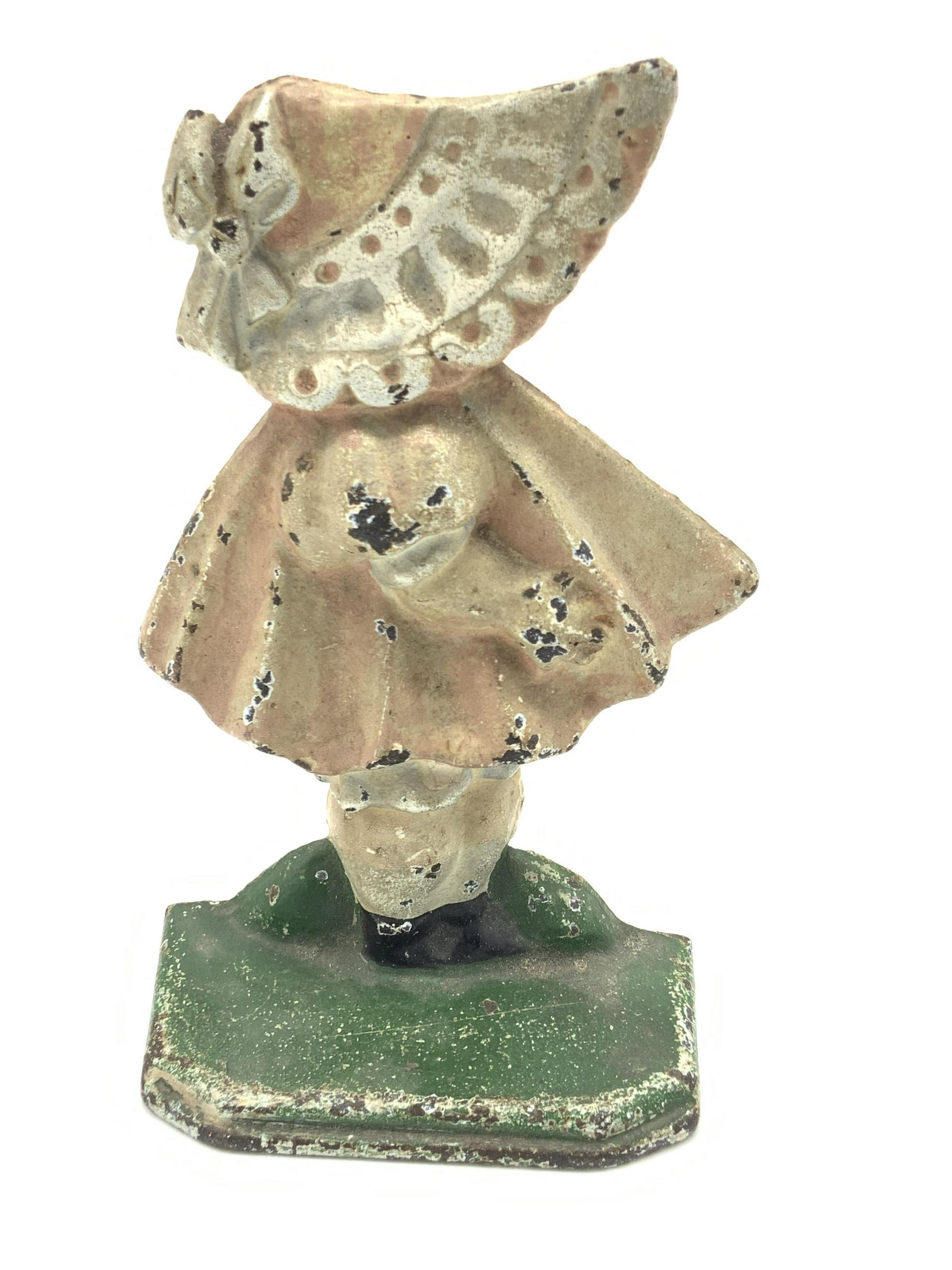Vintage Hand Painted Iron Girl Figural Doorstop: A vintage, possibly antique, hand painted doorstop crafted from metal, possibly iron, and molded to resemble the form of a girl wearing a bonnet and dress. Piece is primarily white, pink, and green hu