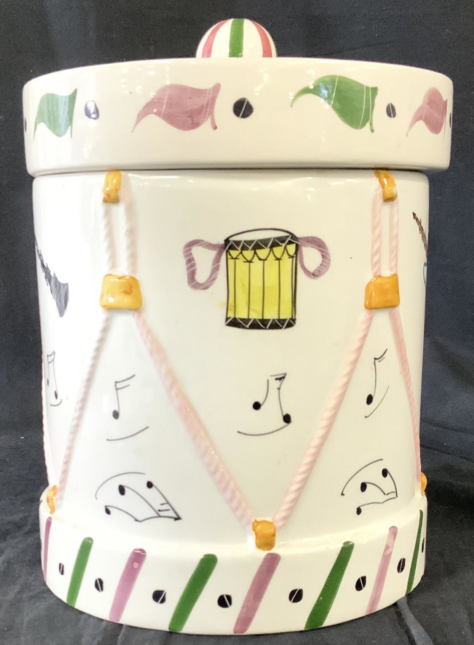 Hand Painted Musical Motif Cookie Jar, Italy: White Ceramic Cookie Jar With lid, whimsical drum shape, hand painted musical instruments and music notes as decor. Underside Hallmarked MADE IN ITALY, org tag. Vintage. Light underside rim chipping a