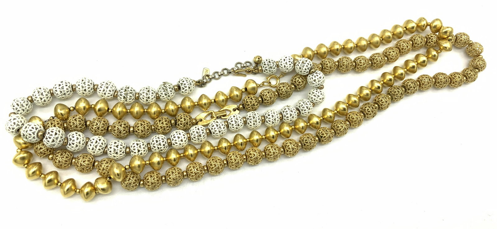 Group 3 MONET Vintage Pierced Ball Necklaces, more: 2 Monet Necklaces of Repeating open work Embossed Ball beads, one goldtone, the other white enamel. Signed Monet clasps or charm. Measure 24 & 16 in. Other necklace not marked, solid gold tone beads, 