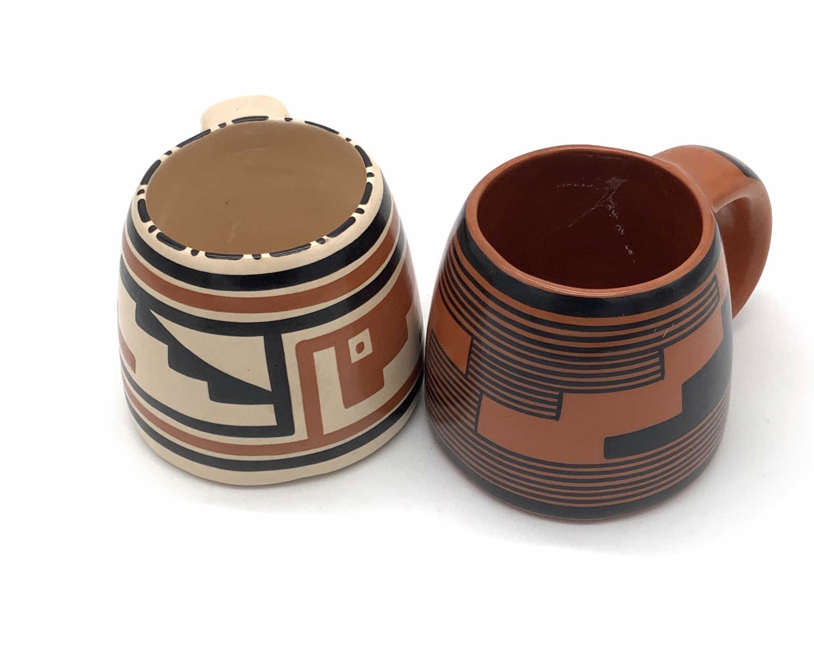 Pair JW Signed Southwestern Style Ceramic Mugs: Two southwestern style ceramic mugs painted with black, brown, and beige hues. Both mugs are signed JW on the underside. After JW, pieces are numbered and signed PINEDALE & KINISHBA, possible artist n