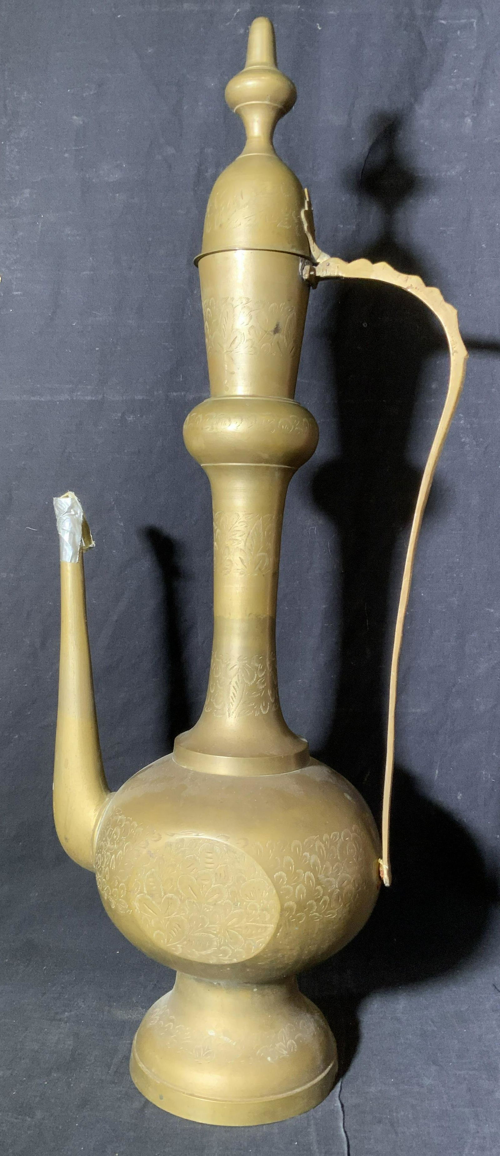 Vintage Brass Lamp: Vintage brass lamp, no apparent inscriptions or markings, nozzle and handle broken, leaf designs to surface throughout, appears to be an old Arabic style gas lamp, lamp measures 31.5 inches at tallest