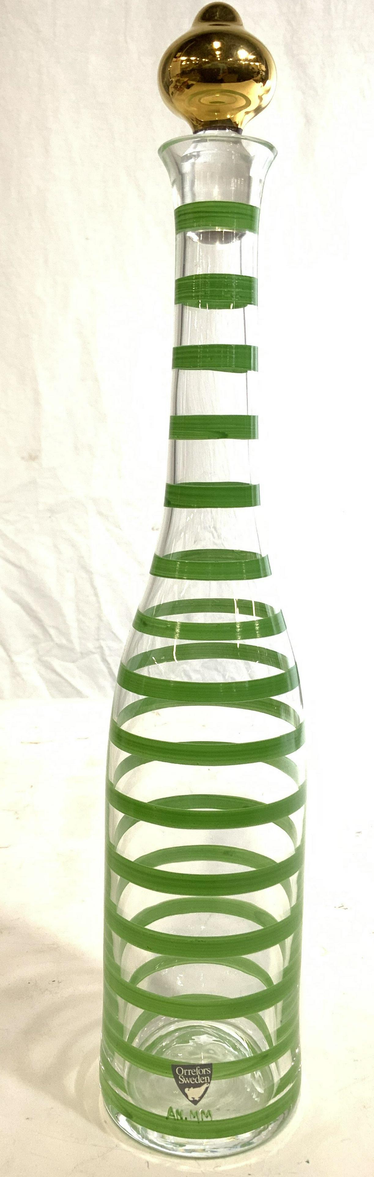 ORREFORS SWEDEN Stripe Detailed Decanter: Tag on lower area reads ORREFORS SWEDEN. Piece appears to be crystal, possibly glass. Decanter has green toned striped detail which appears to possibly be hand painted. Decanter includes stopper. Piec