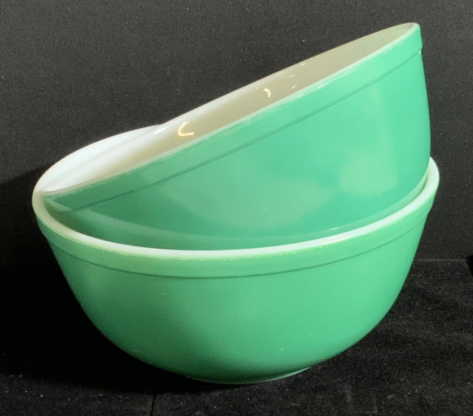 Pair Vintage Green PYREX Trademarked Bowls: Two possibly vintage Pyrex bowls. Both are green hued. Underside reads TRADEMARK PYREX, MADE IN USA, OVENWARE. Larger bowl approx. 4H x 8.5W in. Both pieces feature some discoloration and wear. Vintag