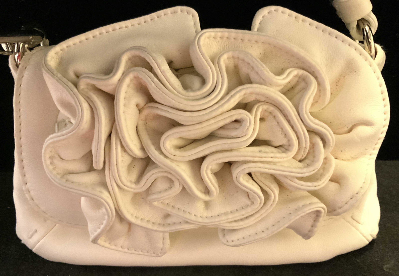 White Leather Rosette Purse: Possibly designer, trademark on snap closure illegible, white leather fold over flap purse with large leather layered rose adornment, heavy chrome hardware detachable strap for handbag into clutch wri