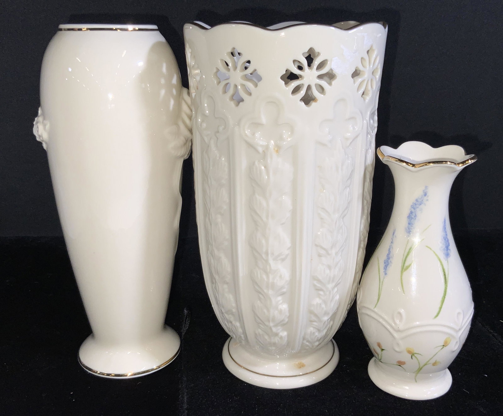 Lot 3 LENOX Signed Porcelain Gilt Accent Vases: Three porcelain vases with gilt accent rims and embossed porcelain details. Various sizes and shapes. Each vase is signed LENOX on the underside. Pieces feature florals, hand painted designs, pierced 