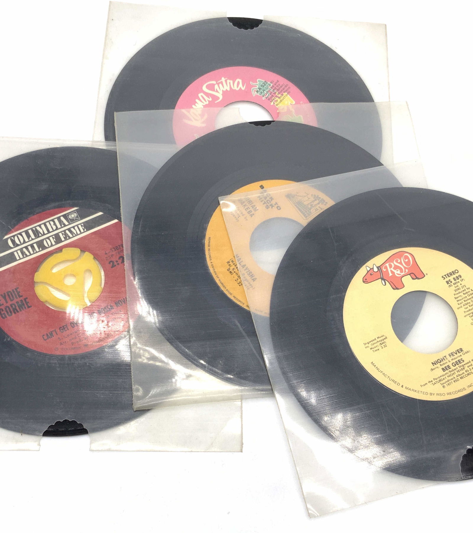 Lot 60 Vntg Vinyl 45 RPM Records, BEE GEES & More: A large group lot of vintage records. 60 in total. Pieces come in a green bag that reads BOOK OF THE MONTH. Some records are loose, some in paper, some in plastic slips. All records appear to be 45 RP