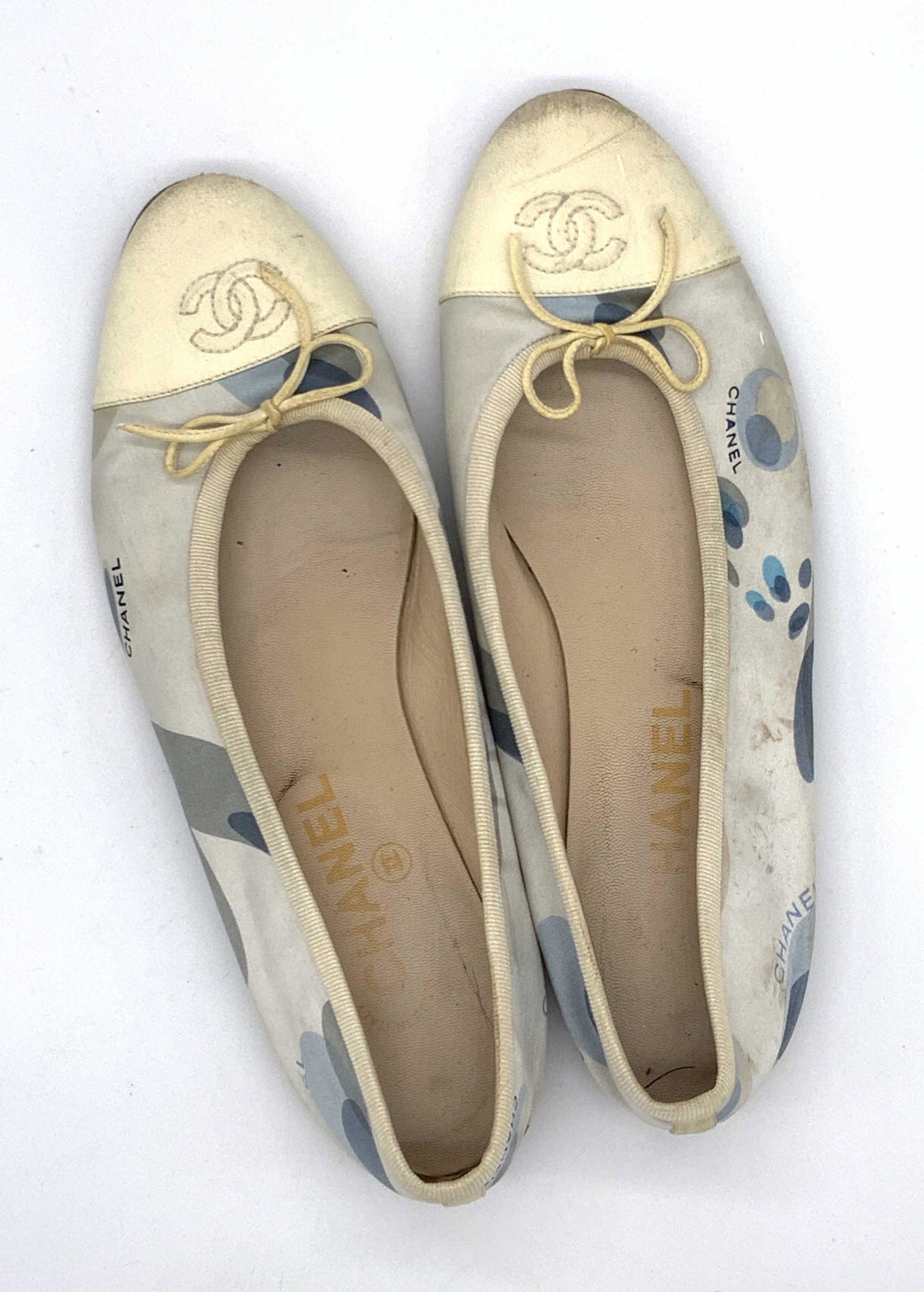 Vntg Signed CHANEL Italian Ladies Shoe, Sz 38 1/2: A pair of CHANEL signed women’s footwear. These flats are comprised of a soft hand, blue hued fabric on the exterior. The name CHANEL is printed alongside blue patterns. The tip of the shoes are acc