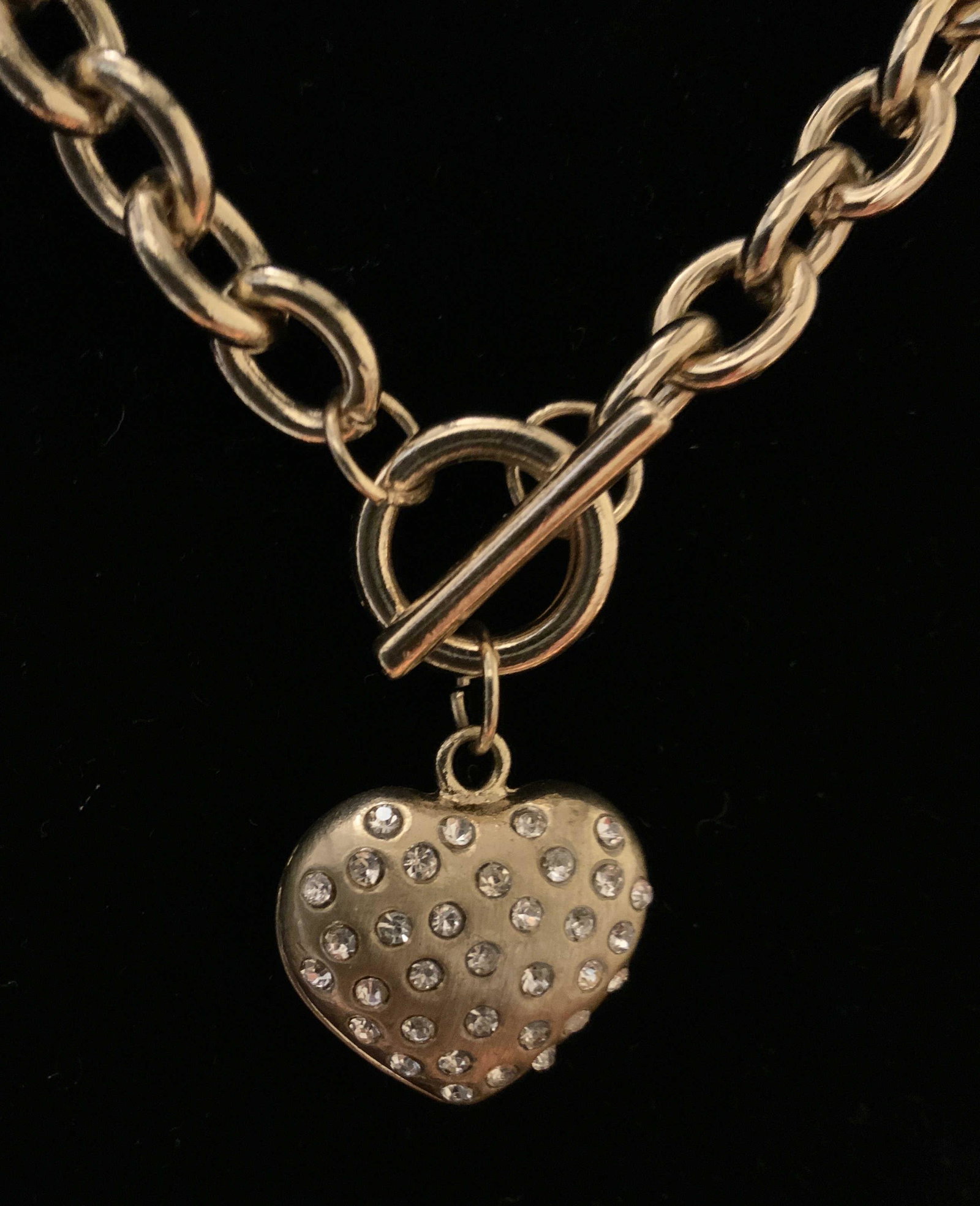 Vintage Gold Tone Heart Pendant Necklace: Gold loop chain drop measures app 8 inches, toggle clasp, and pillow heart pendant, brushed gold style with inset crystal, reverse pillow heart side has cut out heart shapes, pendant size app .75 inch