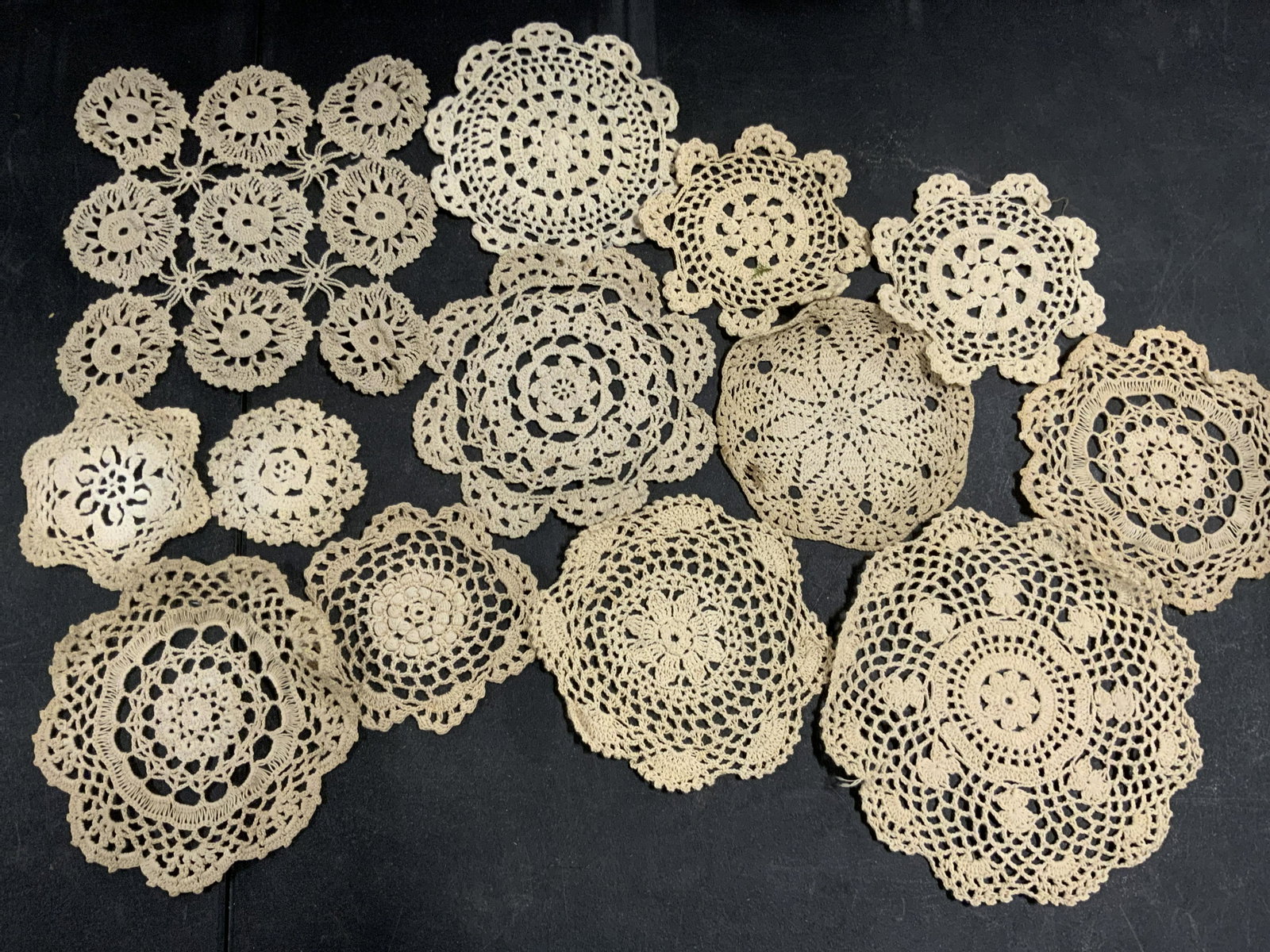 Lot 13 Vntg Handmade Doilies, Circles, Snowflakes: Thirteen vintage handmade doilies. The pieces are circular, snowflake, and square forms. Pieces are primarily beige hued. Varying sizes. Largest Approx. 8.5 x 8.5 in. Pieces have some wear, some disco