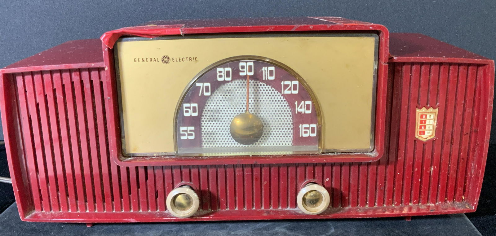 Vntg Mid Century GENERAL ELECTRIC DIAL BEAM Radio: Vintage, mid century, collectible red General Electric Dial Beam radio. Red body. Obverse reads DIAL BEAM, GENERAL ELECTRIC. Knobs turn. Brown cord. Underside has partial sticker. Piece is untested. A