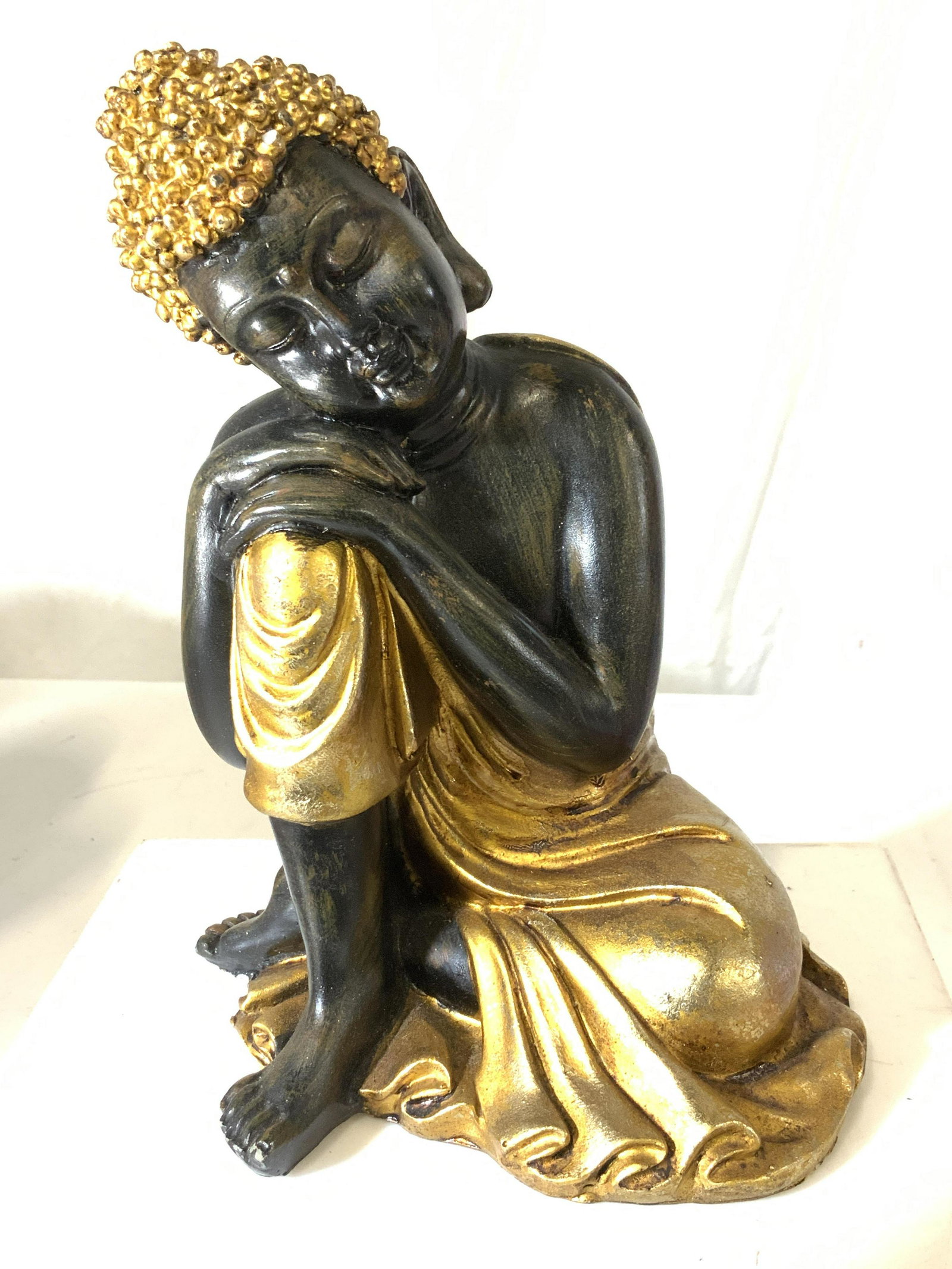 Collectible Gilt Wood Guanyin Buddha Sculpture: Guanyin sits in a moment of tranquil ease, an arm resting on one knee while in deep meditation with closed eyes and minimal dress. dress & Head cowl gold leaf and other wood painted with a light brush