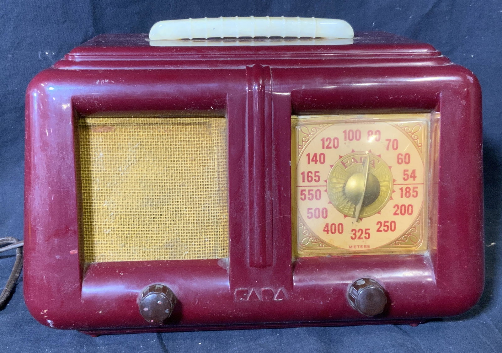 Collectible Vintage Fads Radio: Vintage Fada Radio, text to face of radio reads ‘Kilocycles, Fada, Meters’, radio body made of a red plastics/composite materials, has stretchable handle to top of radio, piece measures 7 inches t