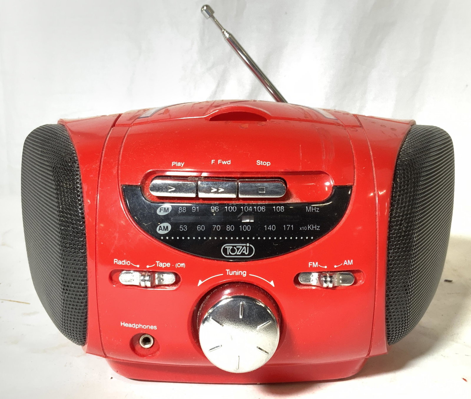 TOZAI C476G Stereo Cassette Tape Player: Underside reads TOZAI MODEL: C476G AF/FM STEREO CASSETTE PLAYER. Piece is red toned with black speakers. Top of piece has flip open cassette player. Front has silver toned chrome style tuning knob, AM