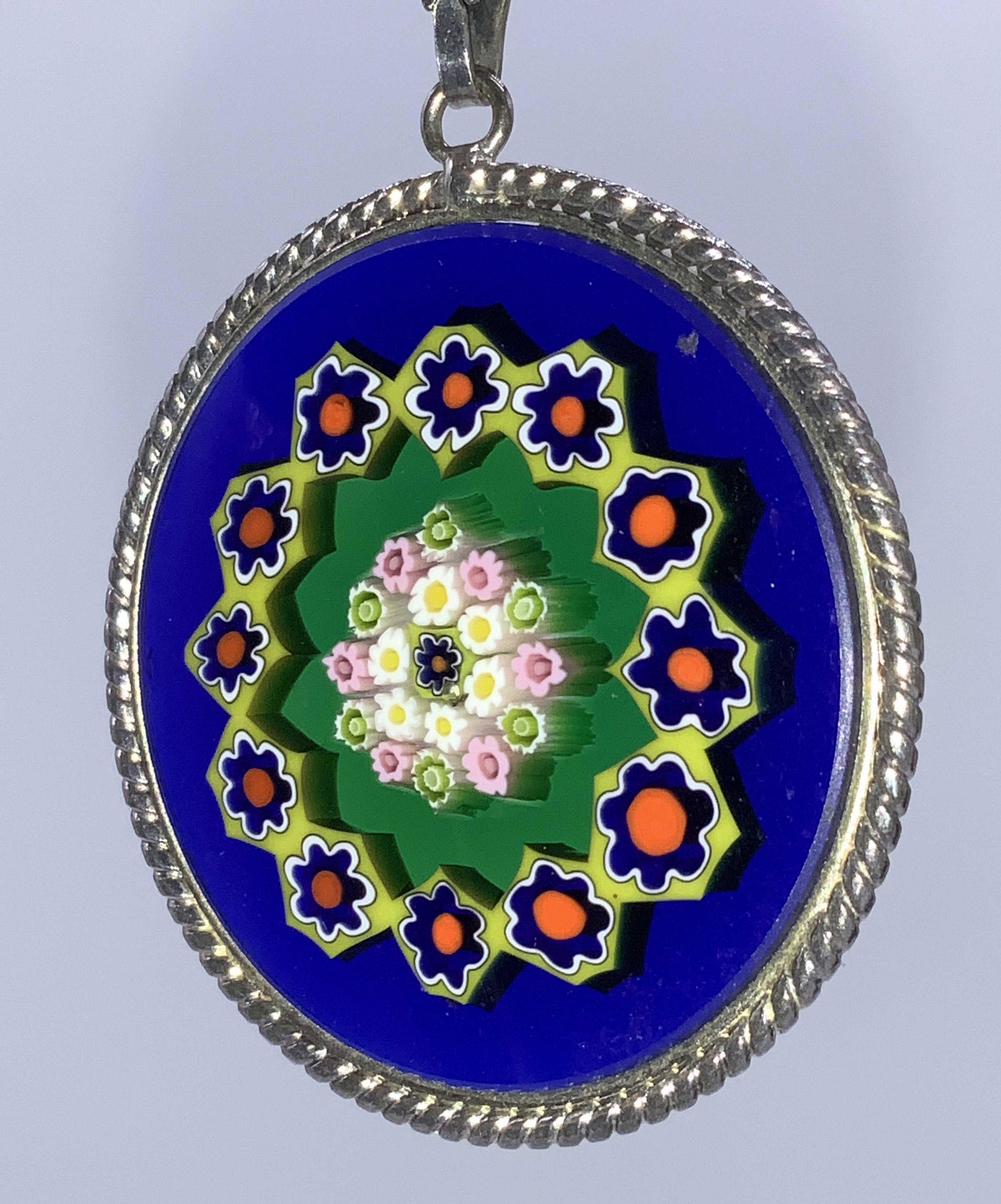 MURANO MILLEFIORI Pendant Necklace Sterling Italy: Handmade Murano glass pendant bezel set in twisted silver, 1 1/8 in. Deep blue with multi chrome millefiori pattern. Bail is signed Italy and 925. Lightweight box chain 24 in. marked 925 on clasp. Cha