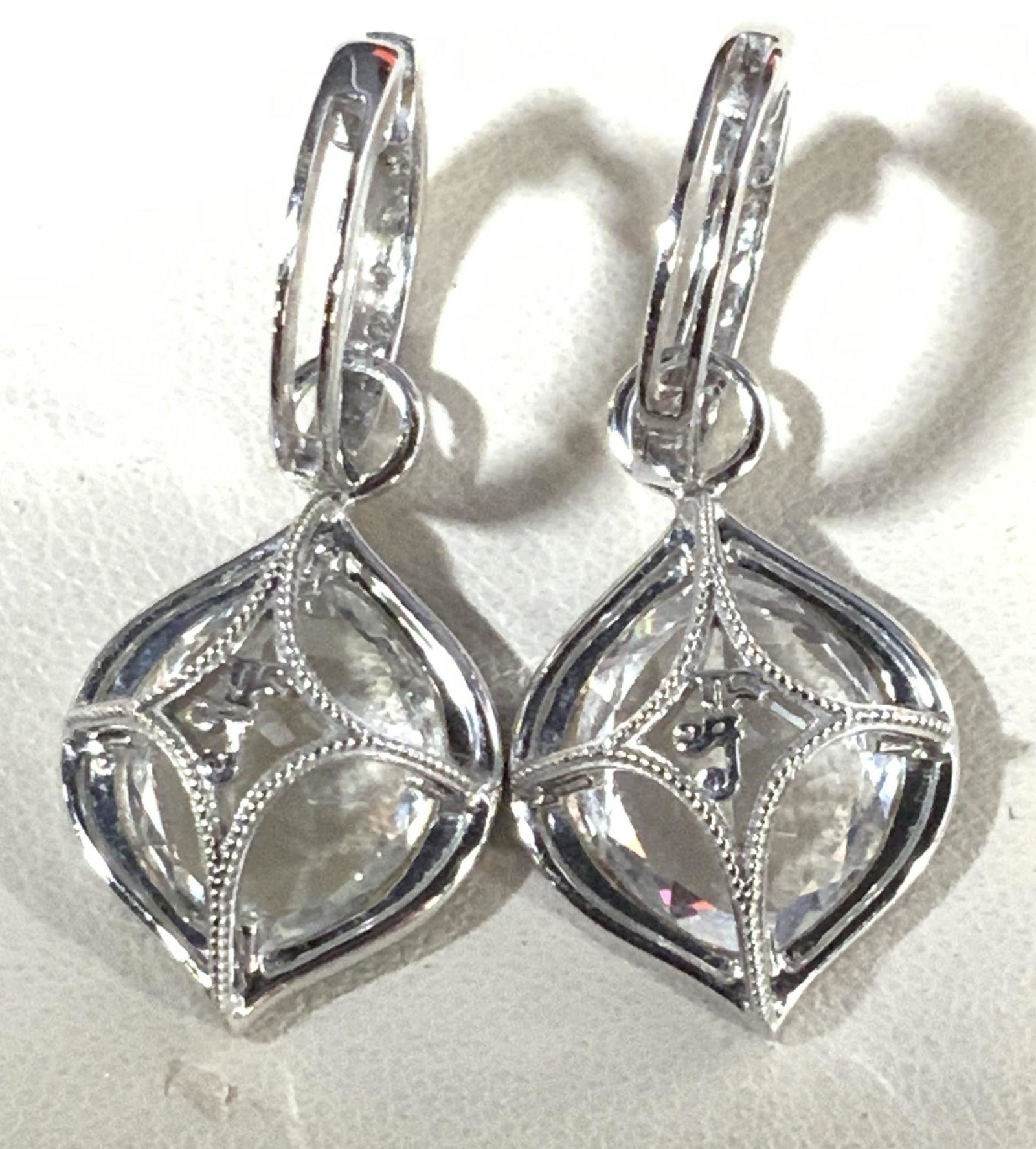 14 K white Gold and Topaz Drop Huggie Earrings: 1 in drop earrings, large center White Topaz stone app 10 mm, surround by diamonté gems, possibly black spinel, huggie style earrings, white topaz stones on huggie. topaz is testing positive on gem t