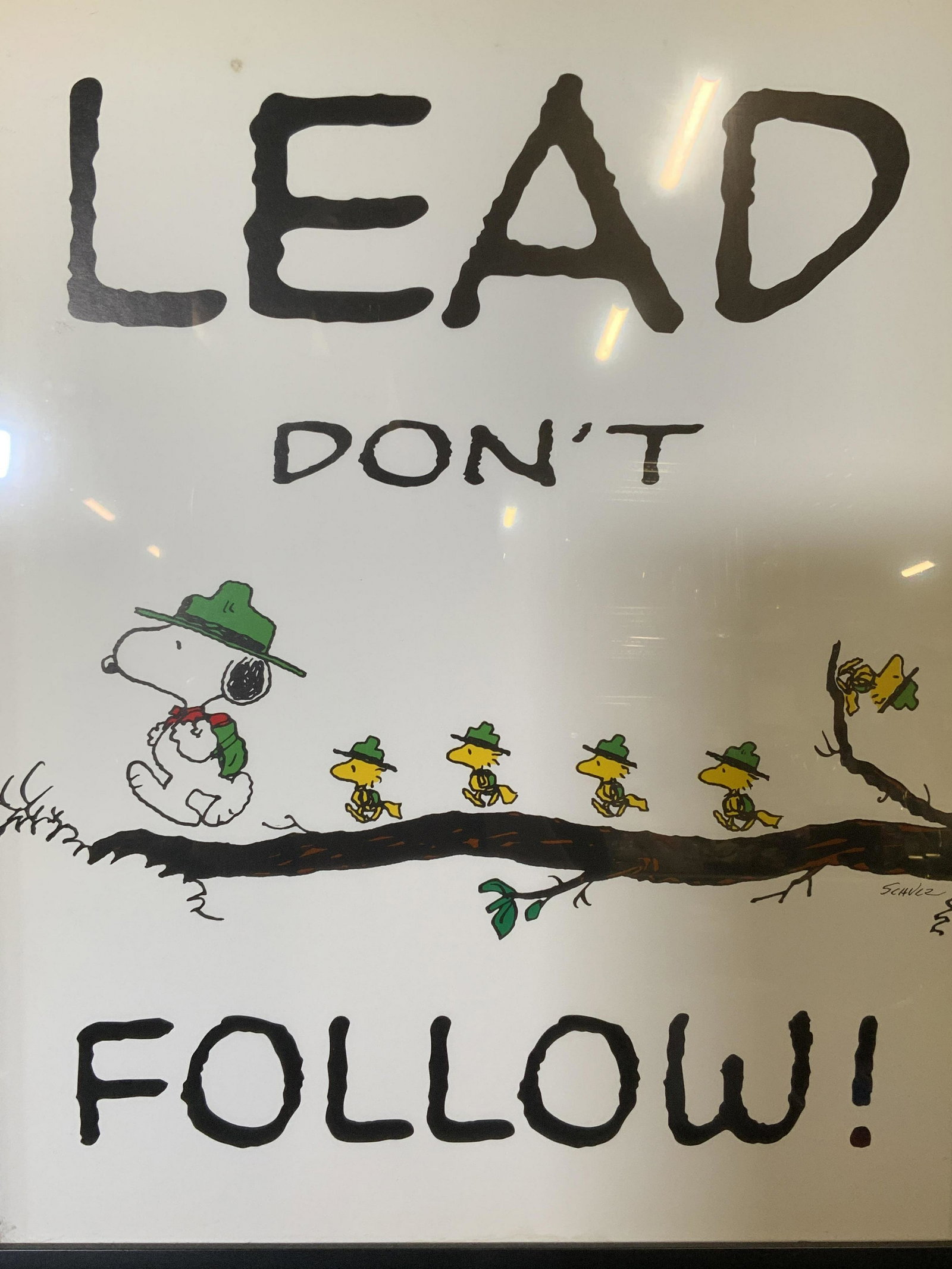 Decorative Snoopy Lithograph Sign: Decorative snoopy lithograph sign, signature printed to the lower right corner reads ‘Shulz’, subject snoopy walking along a branch with mini Woodstocks walking behind him, sign reads ‘Lead don�