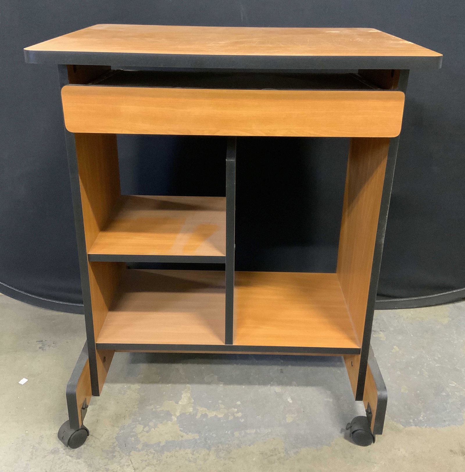End Table On Wheels: Houses several shelves and and extending tray. Sits atop 4 wheels. Measures approx 29 inches H, 23.5 inches W, 18.5 inches deep. Wear is consistent with use, evident surface wear. End table, side tabl