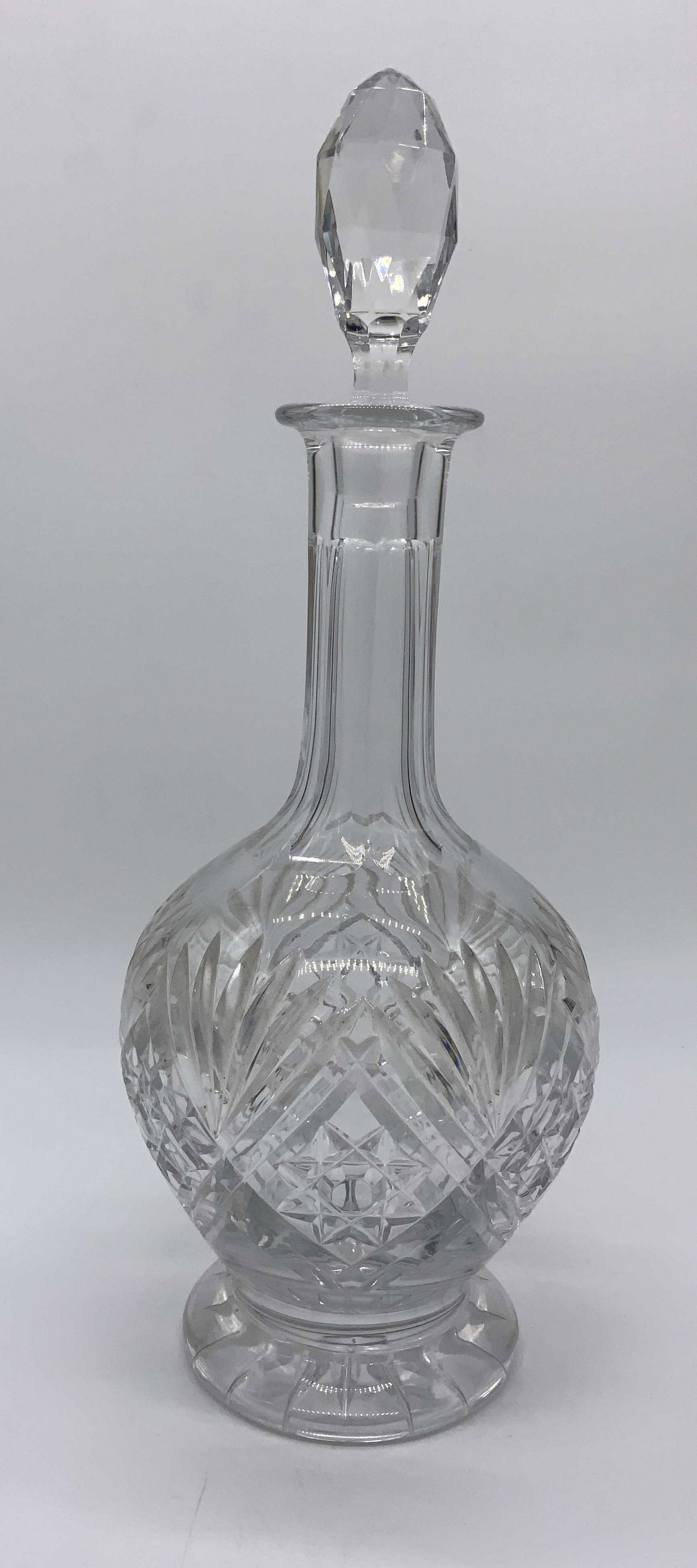 Glass Decanter W Stopper, Barware: Glass decanter, no apparent inscriptions or markings, hand carved designs to surface of decanter shaped like palm fronds, stopper to piece a multifaceted oval, piece measures 13.5 inches at tallest po
