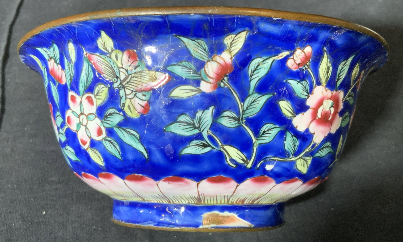 Floral Design Enamelware Bowl Tableware: Enamelware Bowl, no apparent inscriptions or markings, floral decor to exterior, bowl mostly decorated in blue toned, cracks to exterior and interior of bowl, measures 2.75 inches tall and 5 inches in