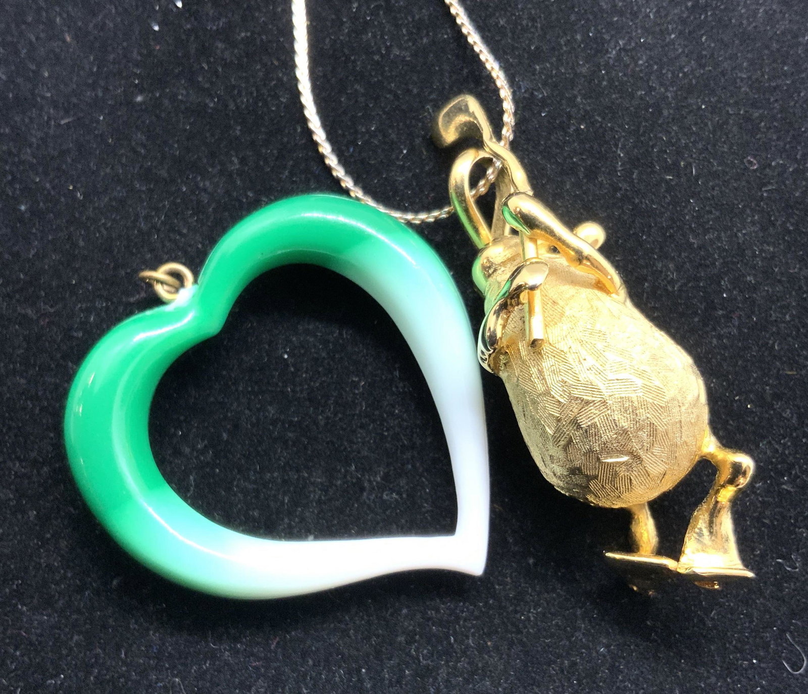 Lot 2 Heart Pendant & Golfer Form Pendant Necklace: Two pieces of jewelry that can be worn together or separately. The open heart form pendant is a green and white ombré tone. The heart has a metal bail that can be used to attach piece to a necklace c