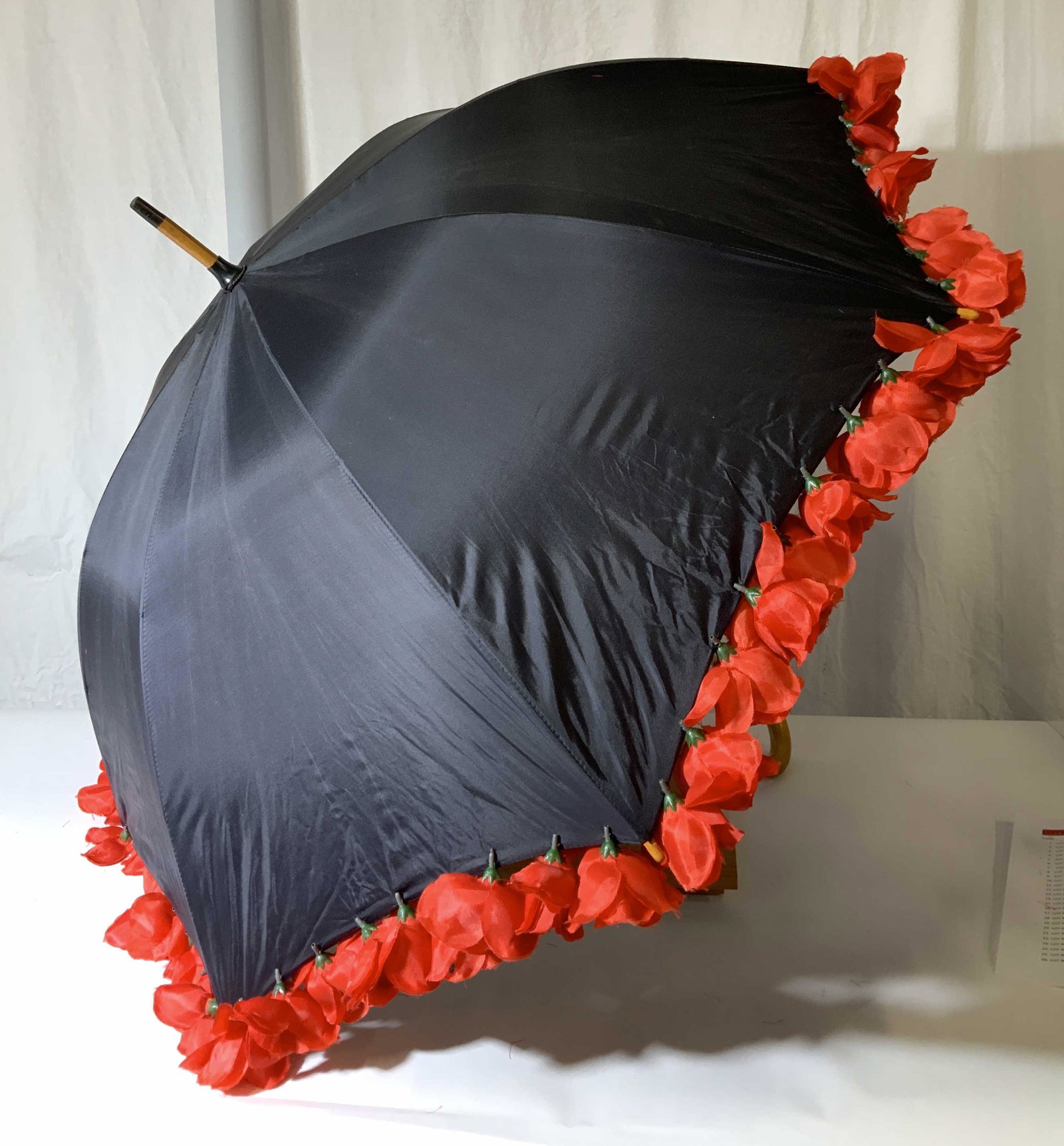 Hopeless Romantic Faux Flower Rimmed Umbrella: Black umbrella with J wood handle. artificial Flowers hang off the edge of umbrella. Moderate fraying of flowers, can be seal with a special fabric glue. Umbrella opens 37.5 in. No issues with umbrell