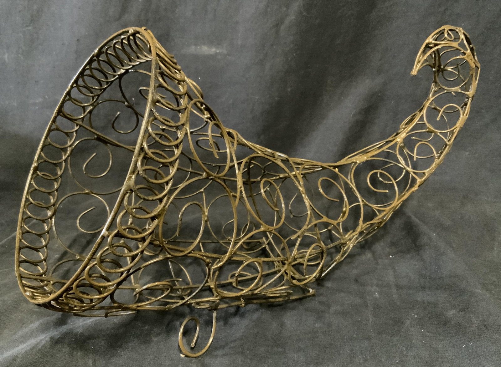 Scrolled Metal Cornucopia: Scrolled Metal cornucopia. One leg is absent, rests on three legs. Measures approx 8.5 inches H and 12 inches W. Wear is consistent age and use. Cornucopia, horn of plenty, centerpiece, tabletop acces