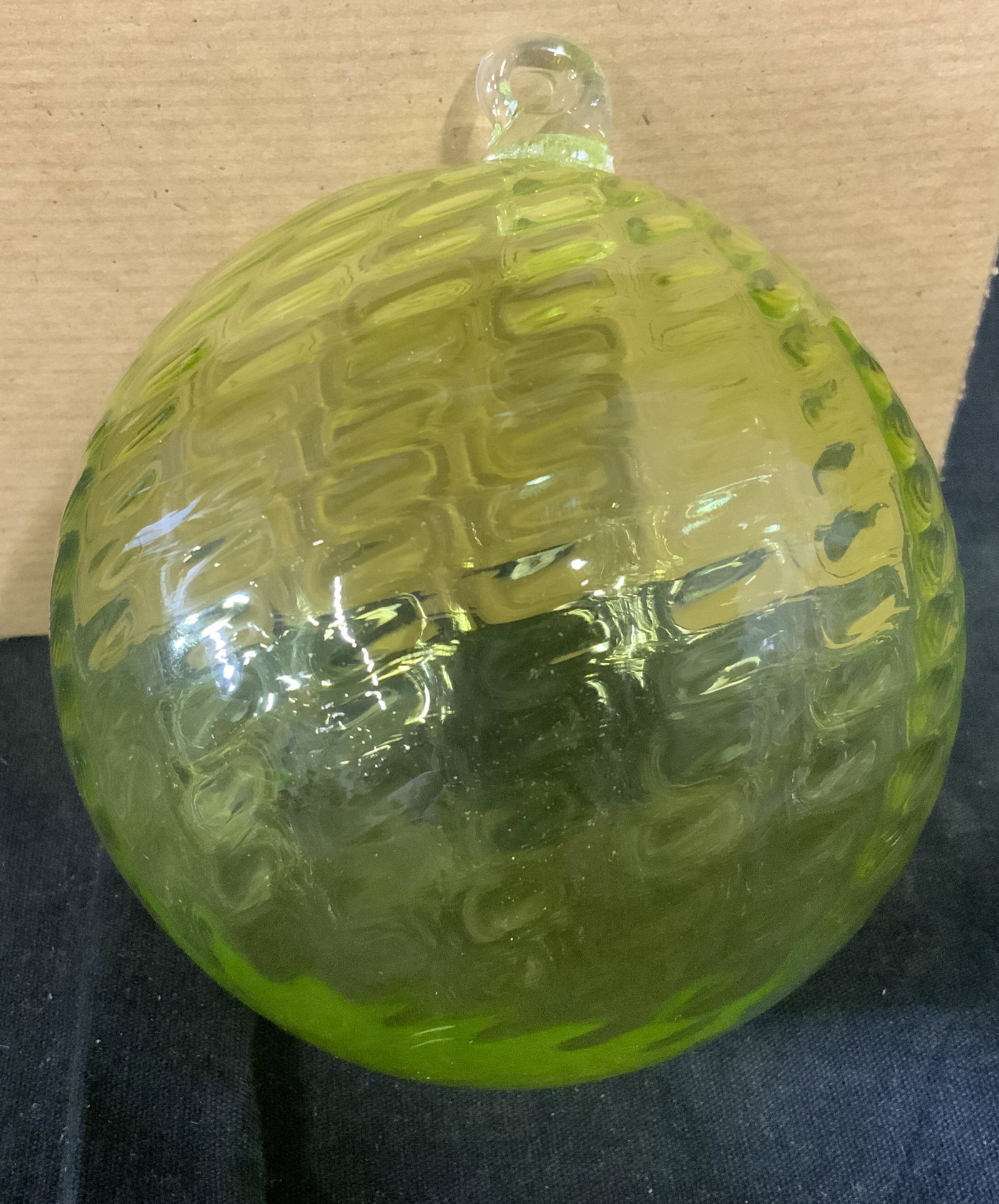 Peridot Orb Glass Christmas Ornament: Peridot Orb Glass Christmas ornament, is titled Peridot Orb with the title tag to the underside of box, brand label stamp to the top of box reads ‘The Artful Home, The Guild’, is a green glass orb