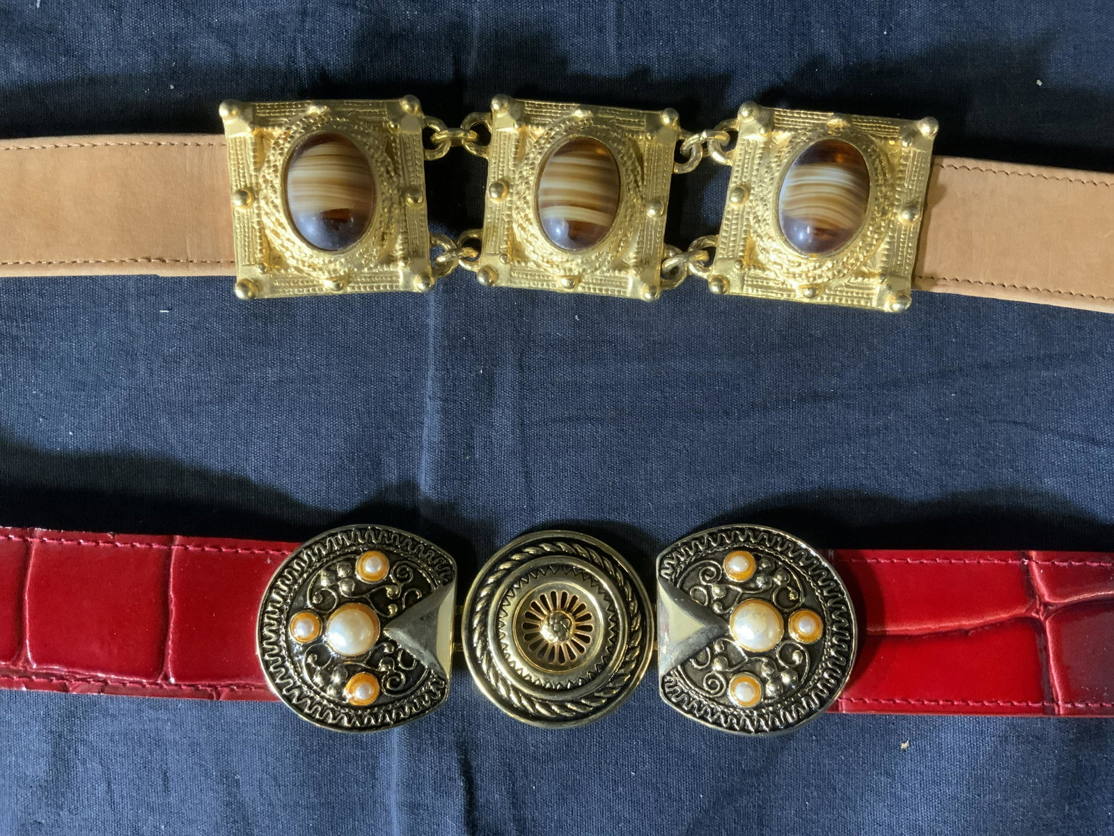 Lot 2 Vintage Leather Belts: Lot 2 Vintage Leather Belts, inscriptions read ‘XS 1667 Carlisle’ and ‘Leather Belt M/L Axessorium #L220 Made in China’, Carlisle belt measures 31 5/8 inches long, red belt measures 38 5/8 inc