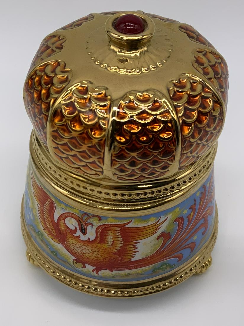 Porcelain Trinket Music Box: Porcelain trinket music box, text to underside reads ‘Firebird TFM’ and ‘Crafter in Taiwan’, box in a circular shape with a pictorial scene to the sides of a man reaching for the tail of a fir