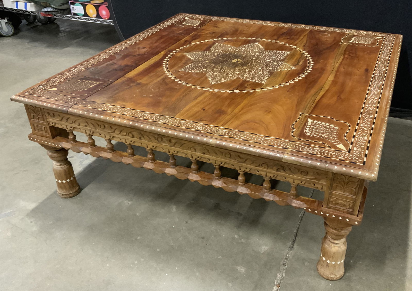 Vintage Moroccan Wooden coffee table w Bone Inlay: Vintage wooden coffee table. Crafted from wood, decorated with multi toned bone inlay. Inlay resembles flowers, vines, and leaf like patterns, plant like detailing also carved into wood. Feet are bell