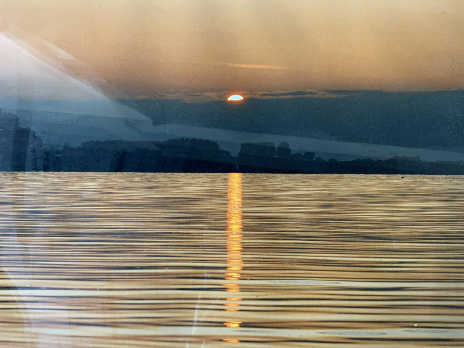 Framed Photograph of a Sunset: Photograph of a Sunset, no apparent inscriptions or signatures, not examined out of frame, subject a sunset over water, measures 15 7/8 x 19 7/8 inches, gold toned composite frame, professionally fram