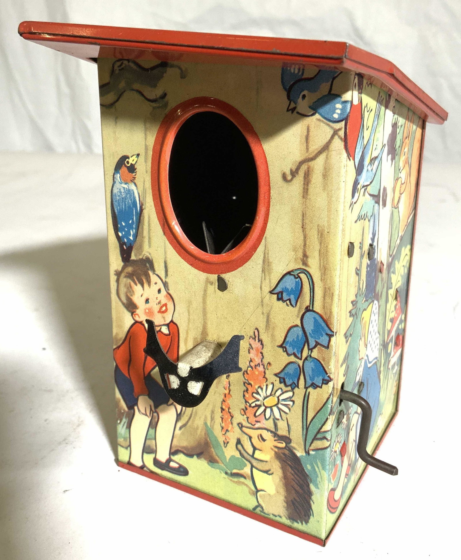 Vintage Metal Crank Birdhouse W Moving Bird Figure: Birdhouse is vintage & metal. Piece has transferred image of boy surrounded by animals. Side of piece has crank which moves bird figure in and out of piece. Piece measures approx 5 inches tall 4 inche