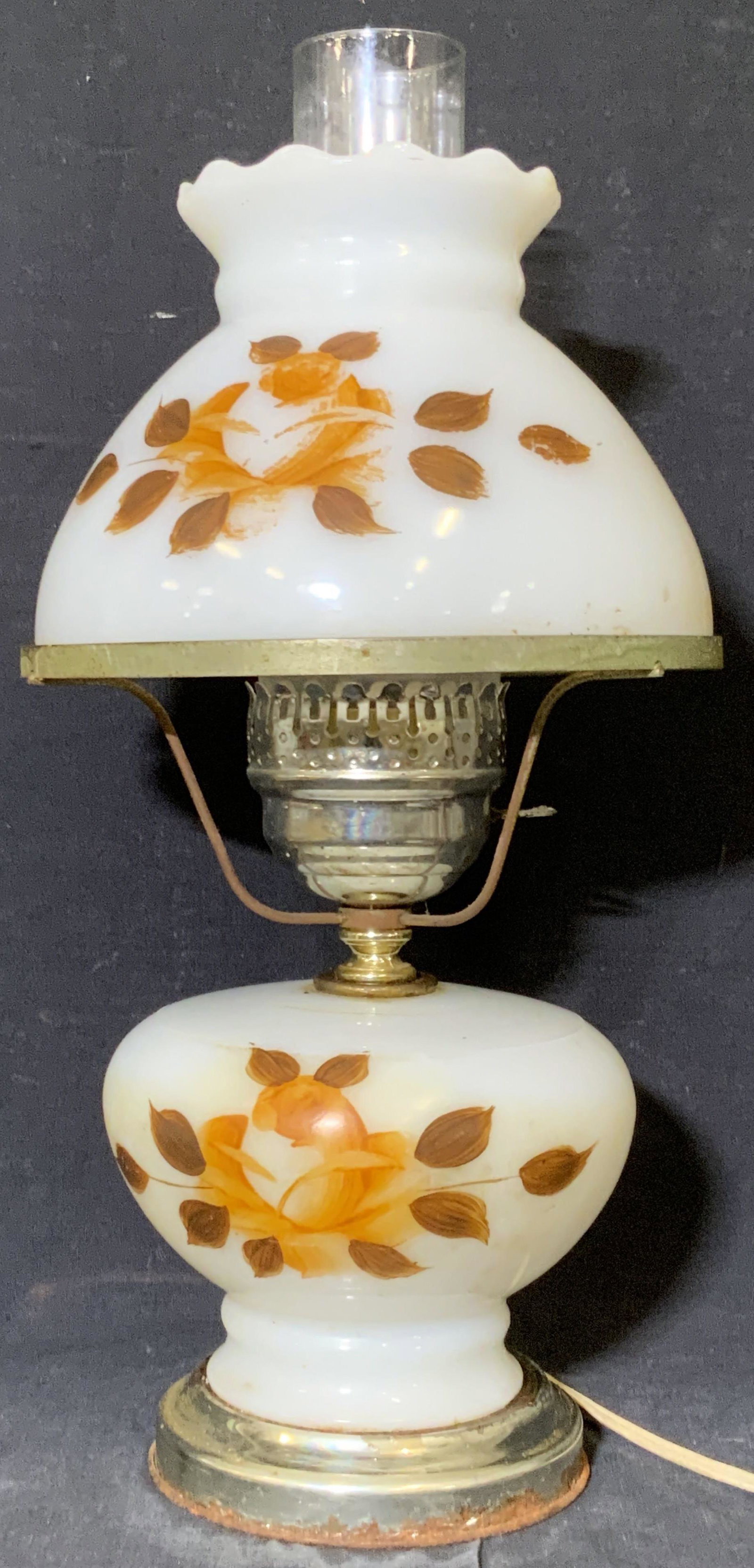 Vintage Floral Gone With The Wind Style Lamp: A vintage glass lamp with a floral motif on the obverse. Piece is hand painted. Primarily white with earth toned orange and brown floral designs. Long beige toned cord. Not tested for working conditio