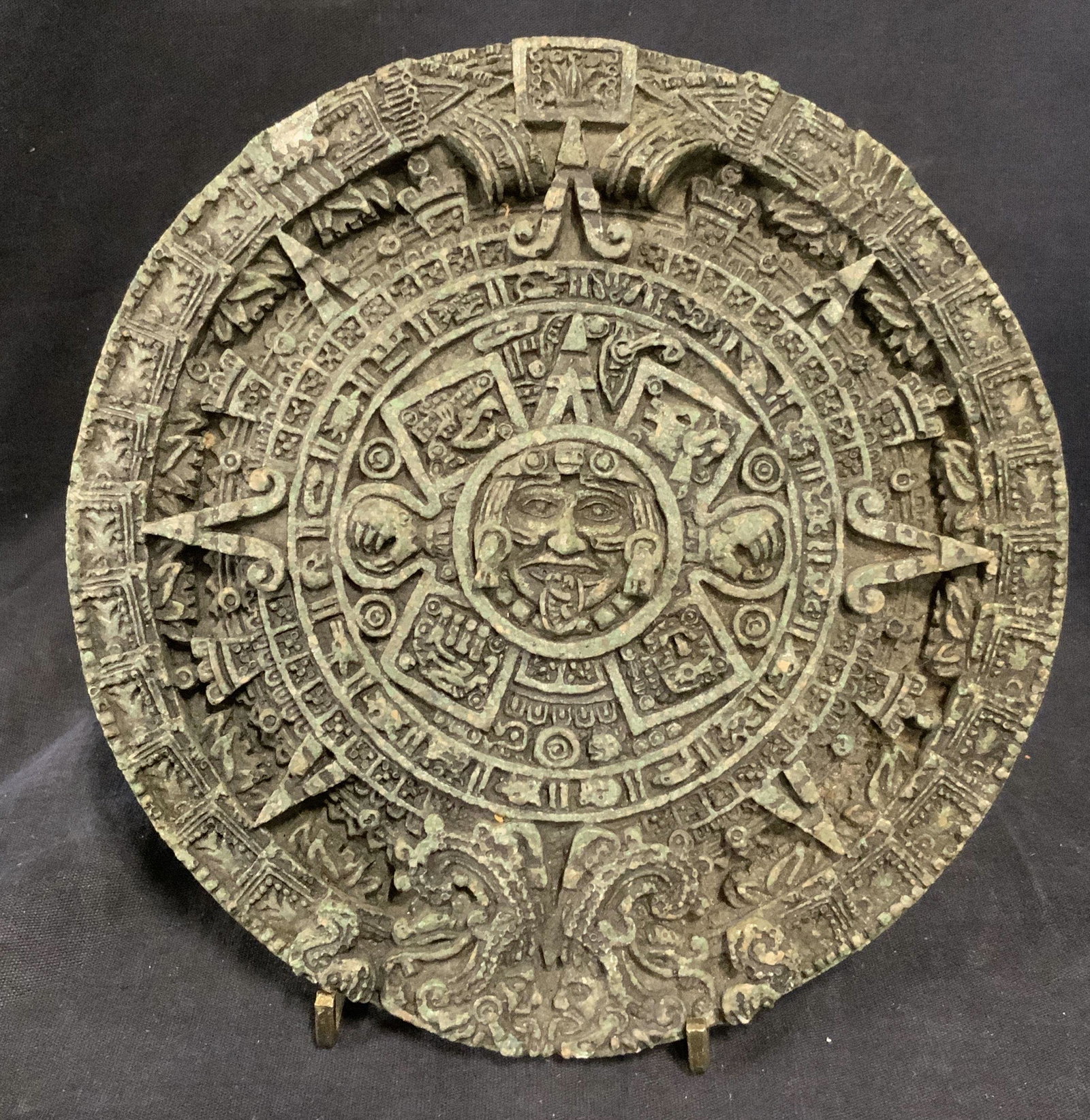 Vintage Mayan Calendar Wall Decor: Vintage Mayan calendar, green in tone. Loop affixed to back allows for mounting. Label on back reads as MADE IN MEXICO. Measures approx 7.25 inches in diameter, some chipping present, wear consistent 