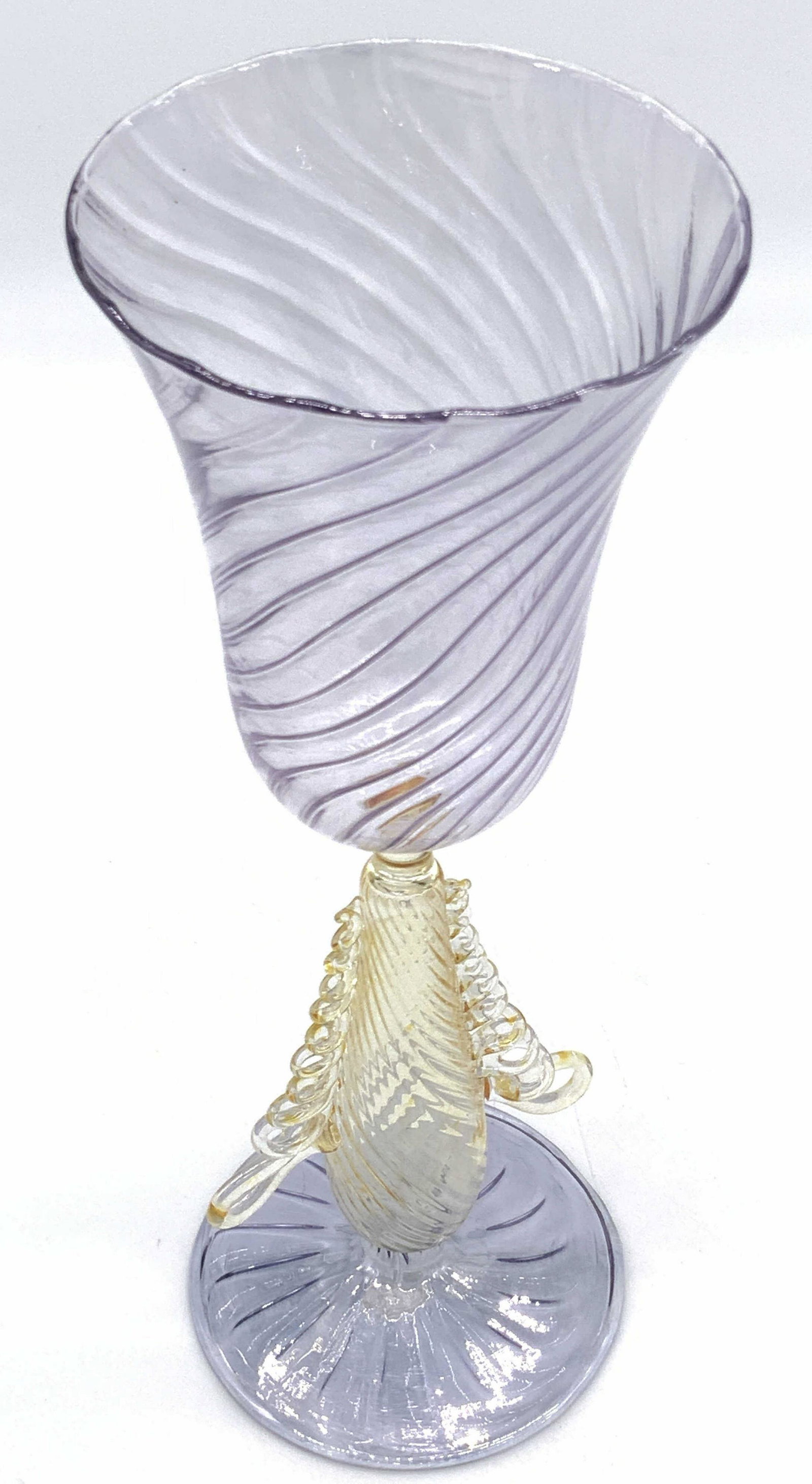 Handmade Venetian Style Art Glass Chalice: An intricately crafted handmade Venetian style glass chalice. The piece features raised and pulled glass designs along the stem and interior of the chalice. Primarily purple and yellow hues. Circular 