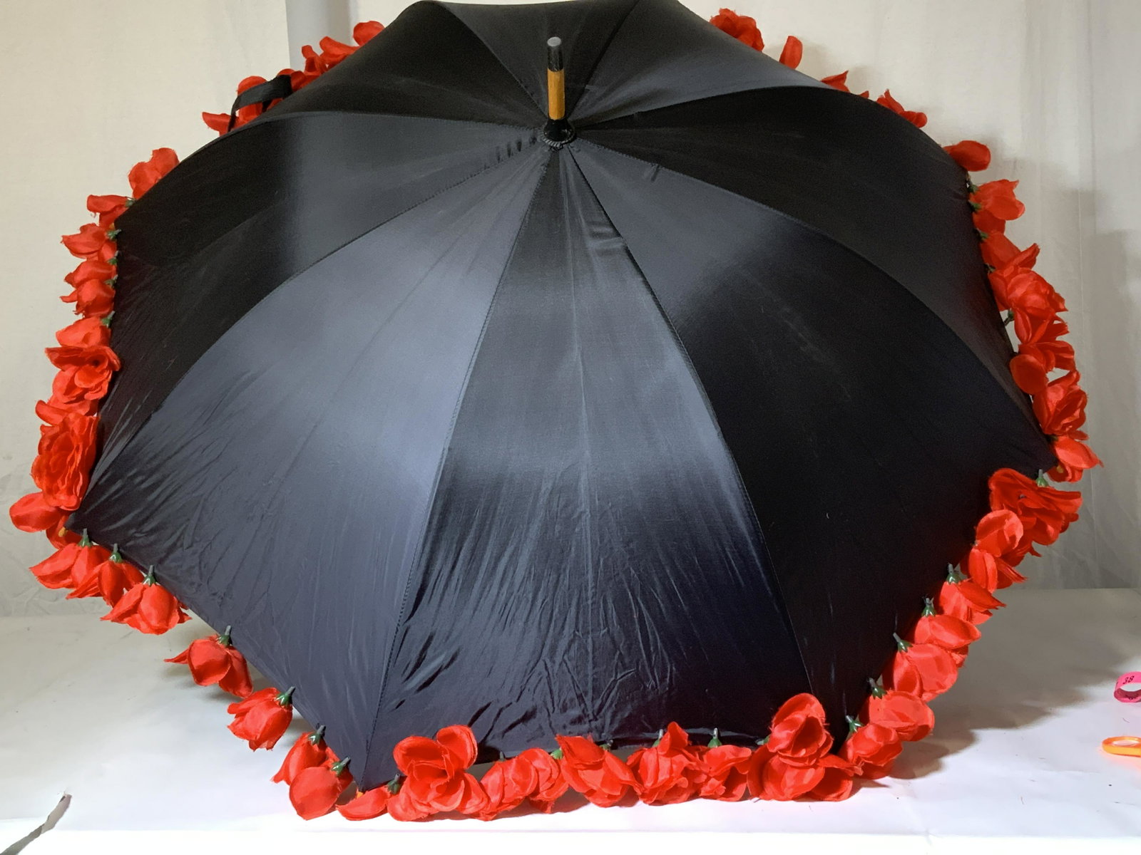 Hopeless Romantic Rose Rimmed Umbrella/ Parasol: Black umbrella 41 in wide when opened, labeled Hopeless Romantic, Velcro closure,. Has stitched faux red roses on edge ( a few missing), wood J handle pinch to open, use for rain or sun or Up cycle ro
