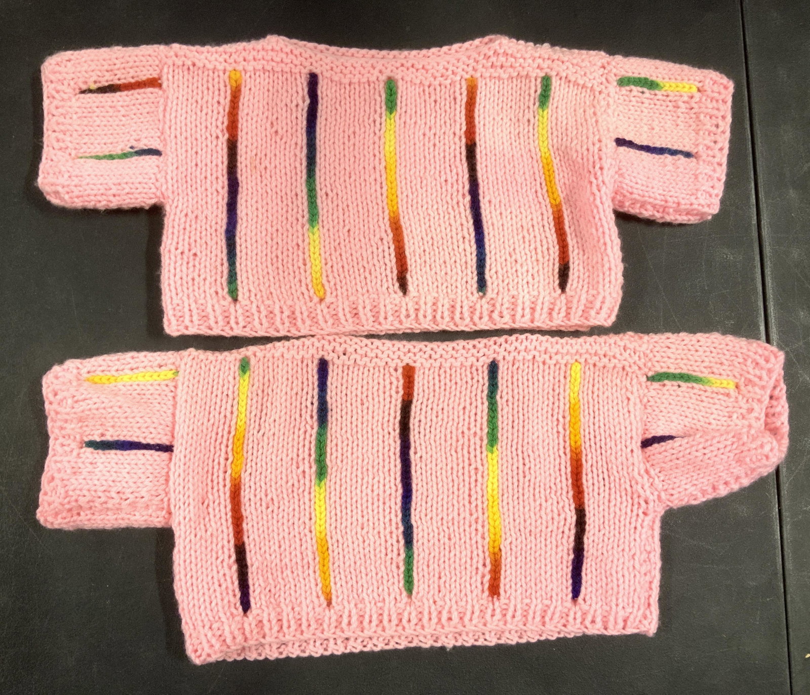 Lot 4 Hand Knit Young Children Sweaters: 3 Pink, 1 Teal, all with rainbow vertical stripe pattern. Slit neck opening , short sleeves, bit of stretch, teal is smallest measures 13 in. across/ 23 in waist ., 8 in. Long. Pink measures 14.5 in a
