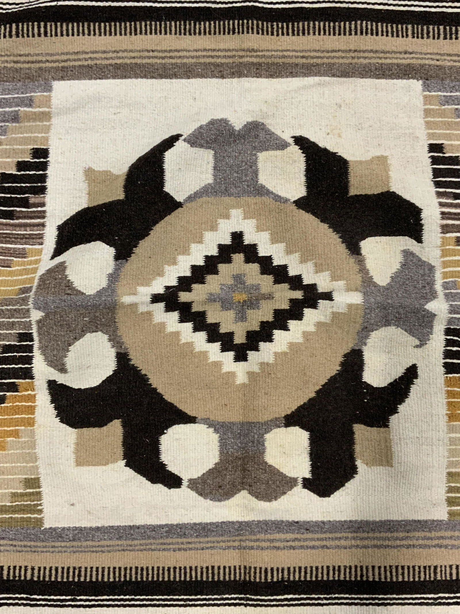 Southwestern Style Area Rug: Vintage area rug, decorated with a southwestern motif. Colored with earthy tones. Ends are fringed. Measures approx 60 inches long, 29 inches W. Wear is consistent with age and use. Area rug, Navajo r