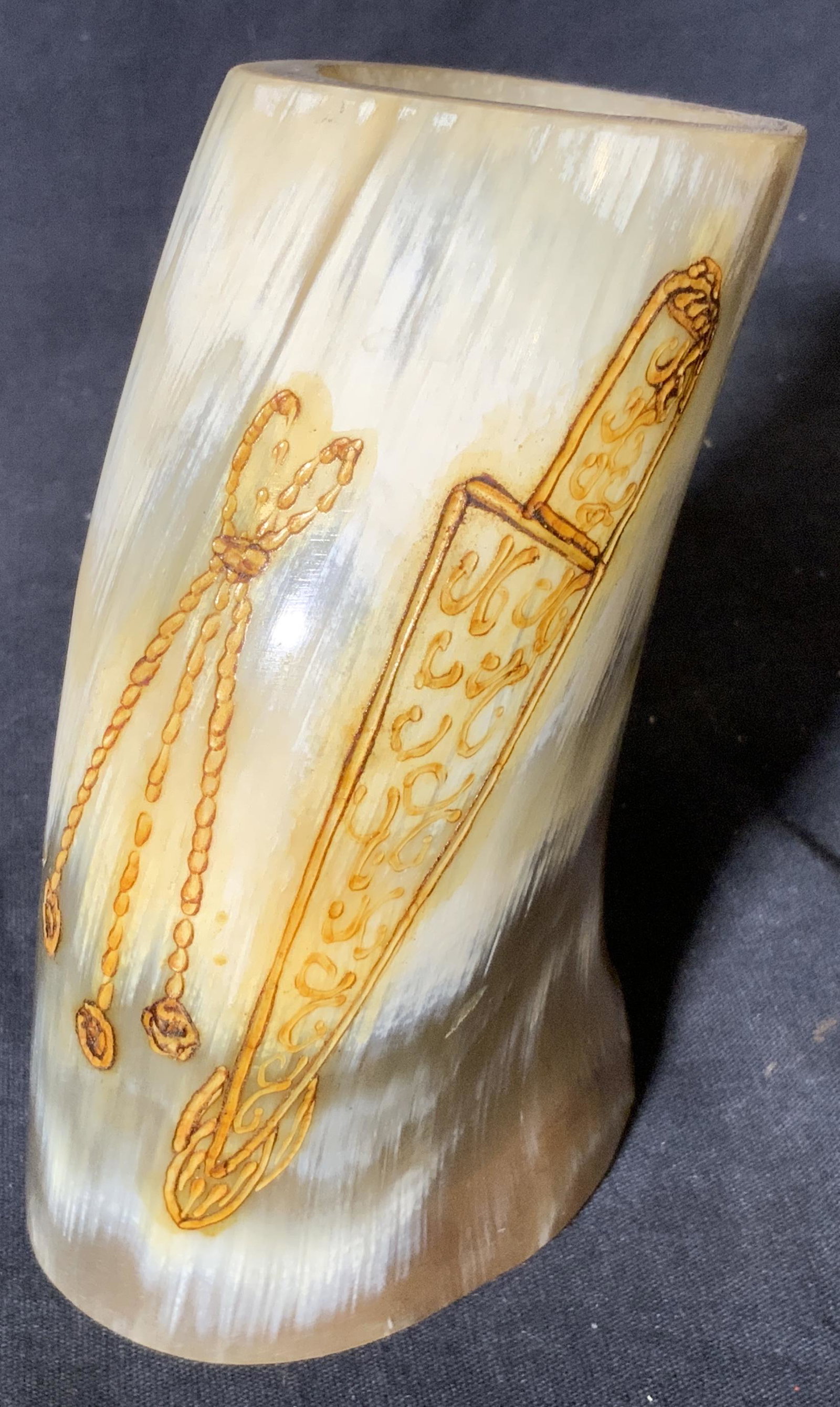 Carved Horn Cup Vessel: Carved Horn Cup, no apparent inscriptions or markings, carved onto the side of the cup is a knife and rope decoration painted in yellow, cup made of hollowed and carved Horn with a wooden piece instal