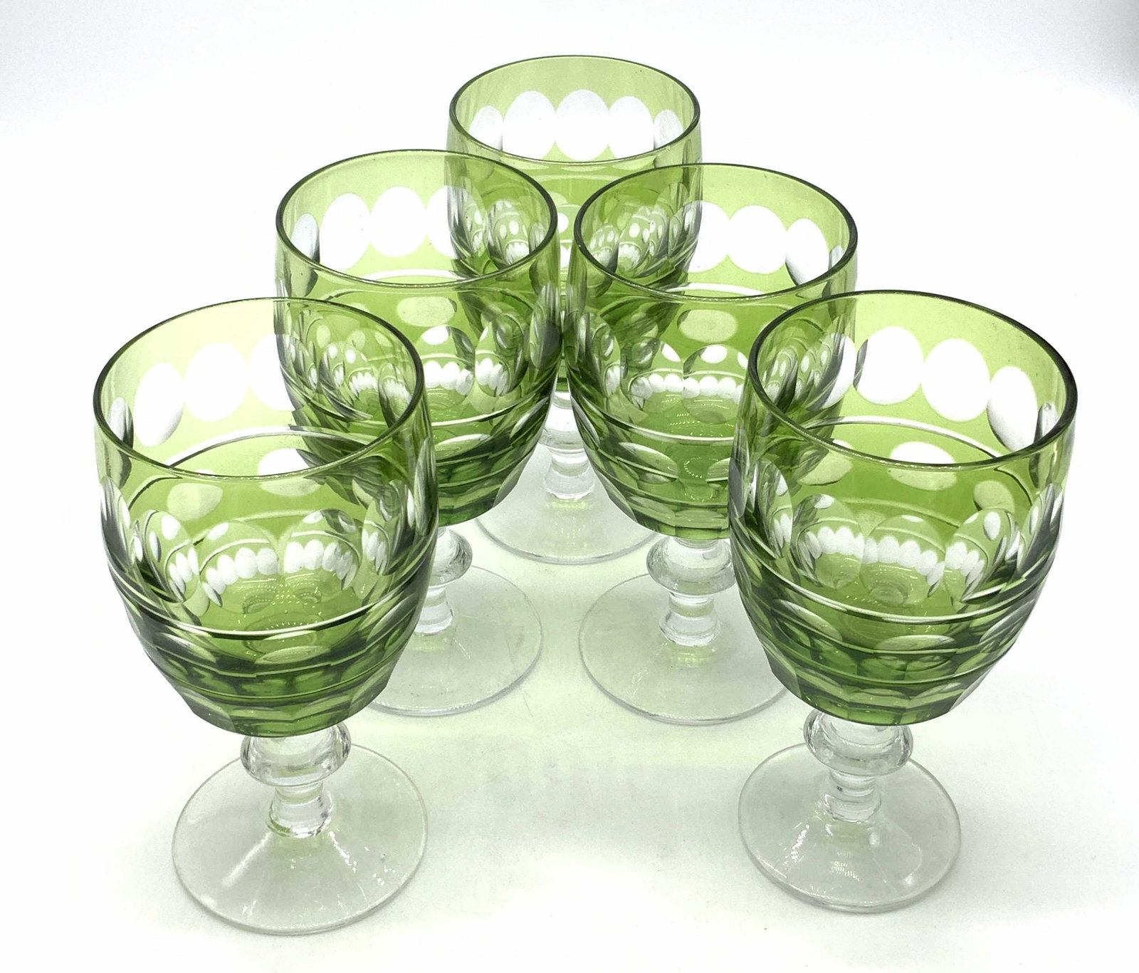 Set 5 Vntg Green Impressed Wine Glasses, Stemware: A set of five green hued wine glasses. Stemware. Impressed glass accents throughout the pieces. Measure approx, 6H x 3W in. Pieces possess some surface wear. Some bubbles in the glass. Property from F
