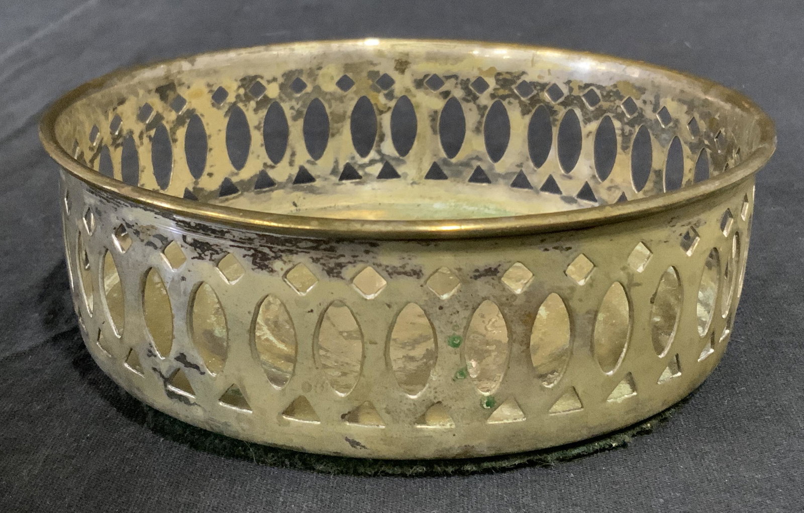Silver Plated Wine Bottle Coaster: Vintage silver plated wine coaster. Sides are pierce, underside is lined with green fabric. Measures approx 5 inches in diameter. Wear is consistent with age and use. Silver plate, wine bottle holder,