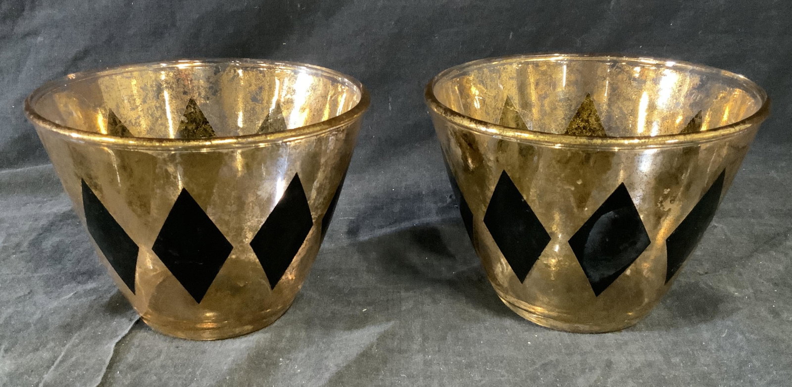 Pair Metallic Art Glass Bowls: Pair metallic art glass bowls, no apparent inscriptions or markings, subject two bowls or vessels with gold metallic coloring to them and black diamond designs to the exterior, both measure 4 inches t