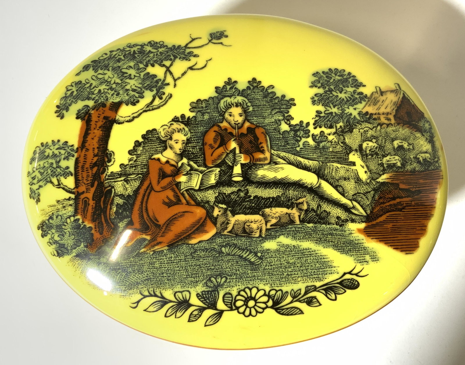 MOTTAHEDEH Porcelain Trinket Box W Lid: Underside of piece is marked MOTTAHEDEH PORTUGAL. Piece is yellow toned with multi toned detail depicting 2 figures seated outdoors on lid. Sides of piece have multi toned vine and leaf detail. Piece 