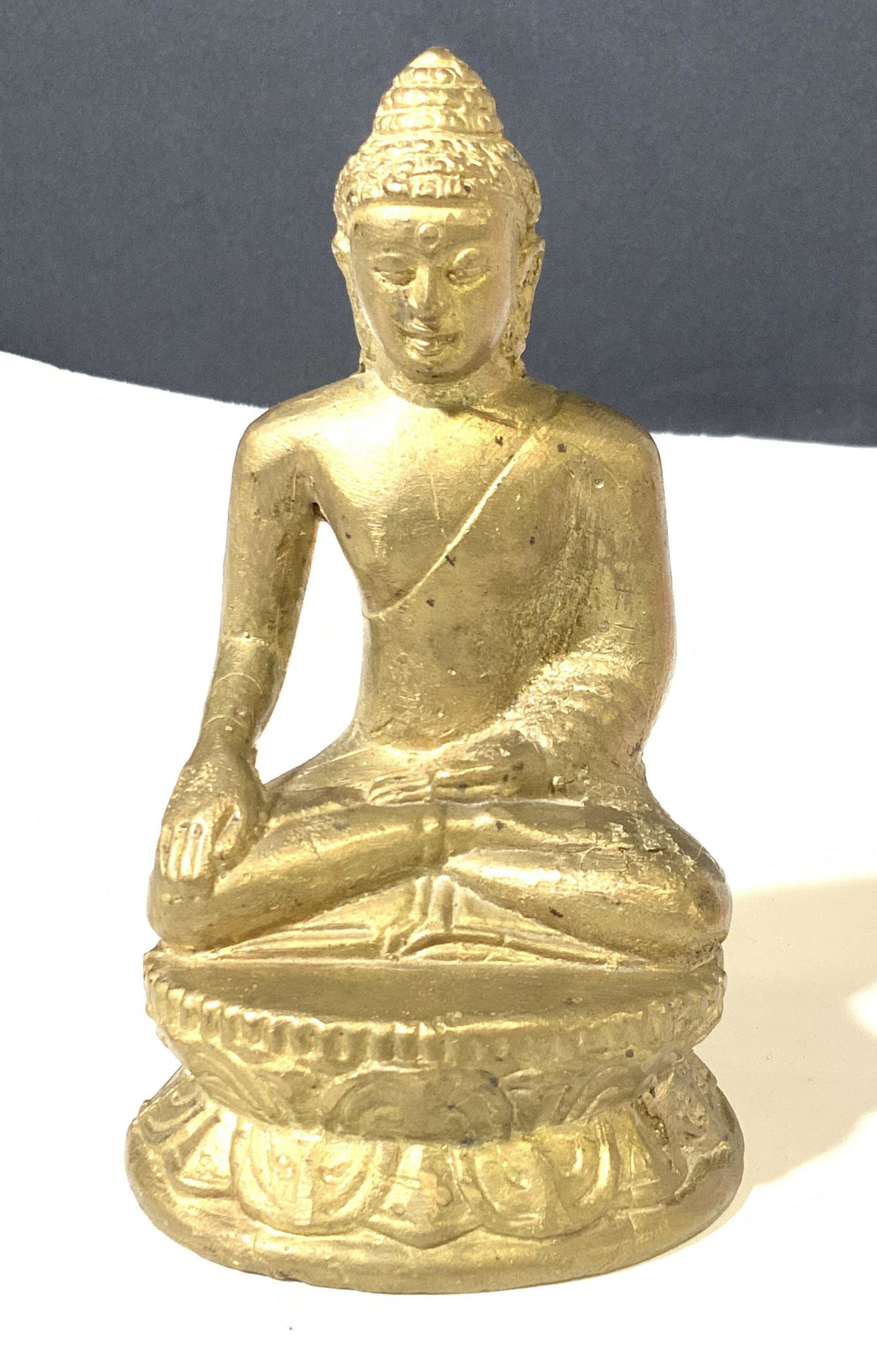 Gold Washed Seated Metal Guanyin: Seated in the ‘royal ease’ position is this asian Goddess Figural painted in a gold wash. Sits with crossed legs, hand on knee and other hand on ankle. Measures 5.25 in ht. , 3in. Wide. The female