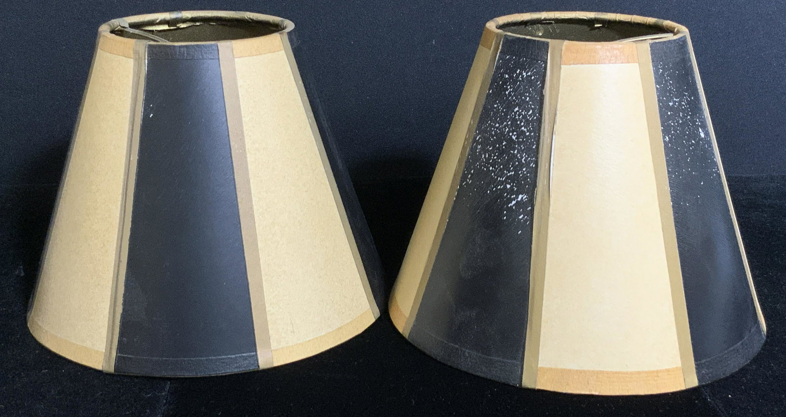 Pair Vertical Striped Paper Lampshades: A pair of paper lampshades decorated with black and sandy hued vertical stripes. Approx. 5.5H x 6W inches at widest point. Pieces possess some wear. Paper lampshades, lighting accessories, striped lam
