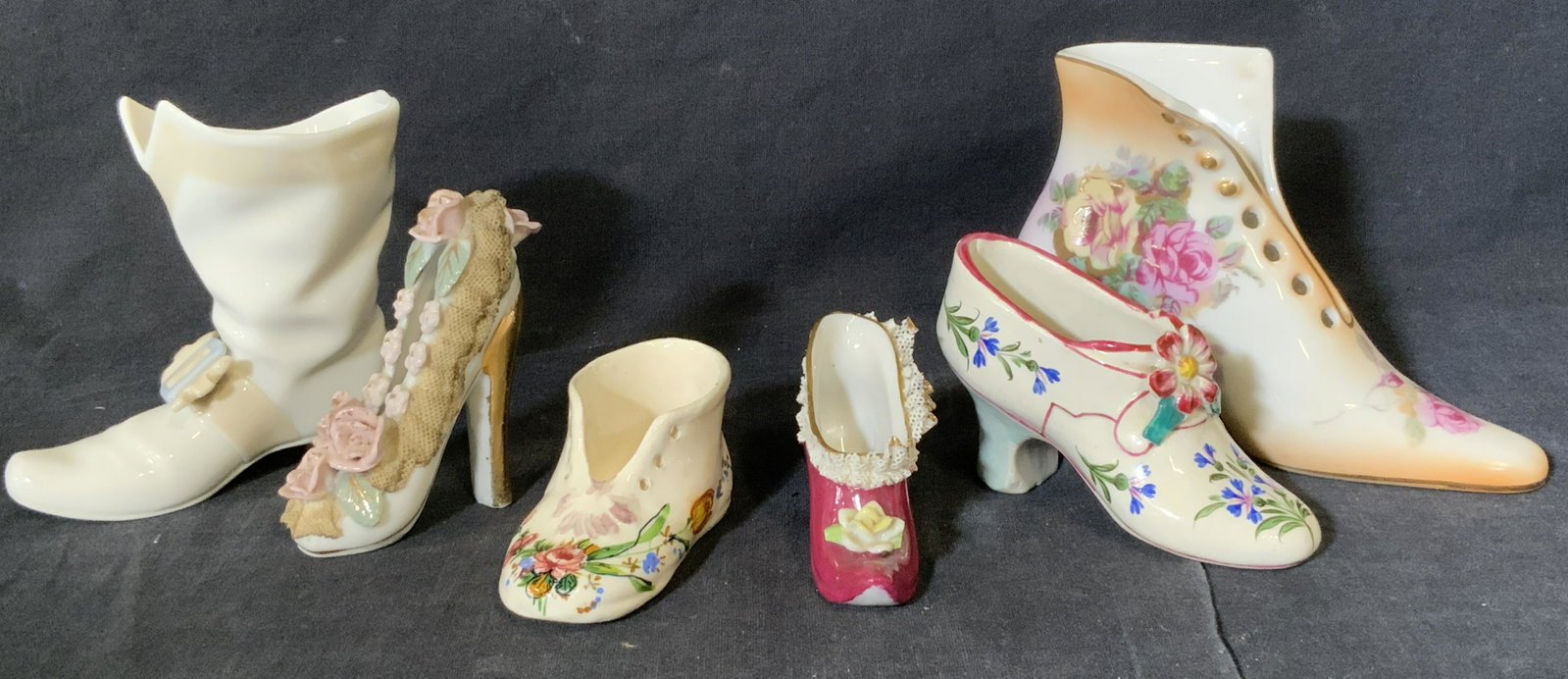 Group Lot 6 Porcelain Shoe Statuettes: Group lot 6 porcelain shoe statuettes, label to underside of one reads ‘R S’, all have floral designs to them with various shoe styles to each, largest one measures 4.25 inches tall by 5.25 inches