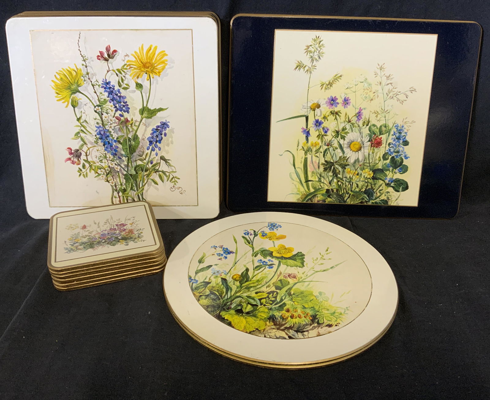 Lot 17 Cork Coasters: Lot 17 cork coasters. Decorated with floral prints, some wear to prints, underside of some coasters read as Made In England. Wear is consistent with age and use. Largest measures approx 11 inches W, 8