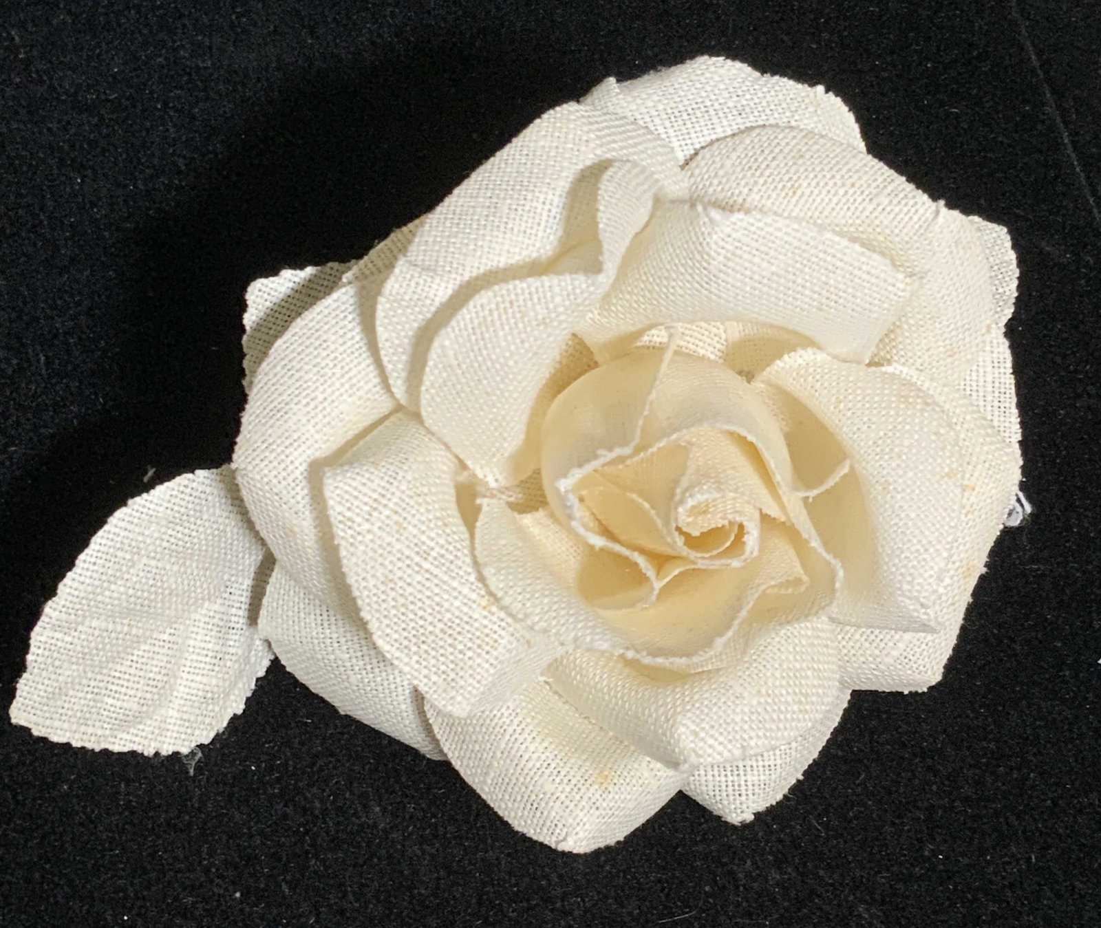 Lot 7 Fabric Floral Napkin Rings: Set of Six white hued rose formed fabric napkin rings, one white and green fabric floral napkin ring. The ring portions are crafted from composite material. Rose napkin rings approx. 3.5H x 4W in. Pie