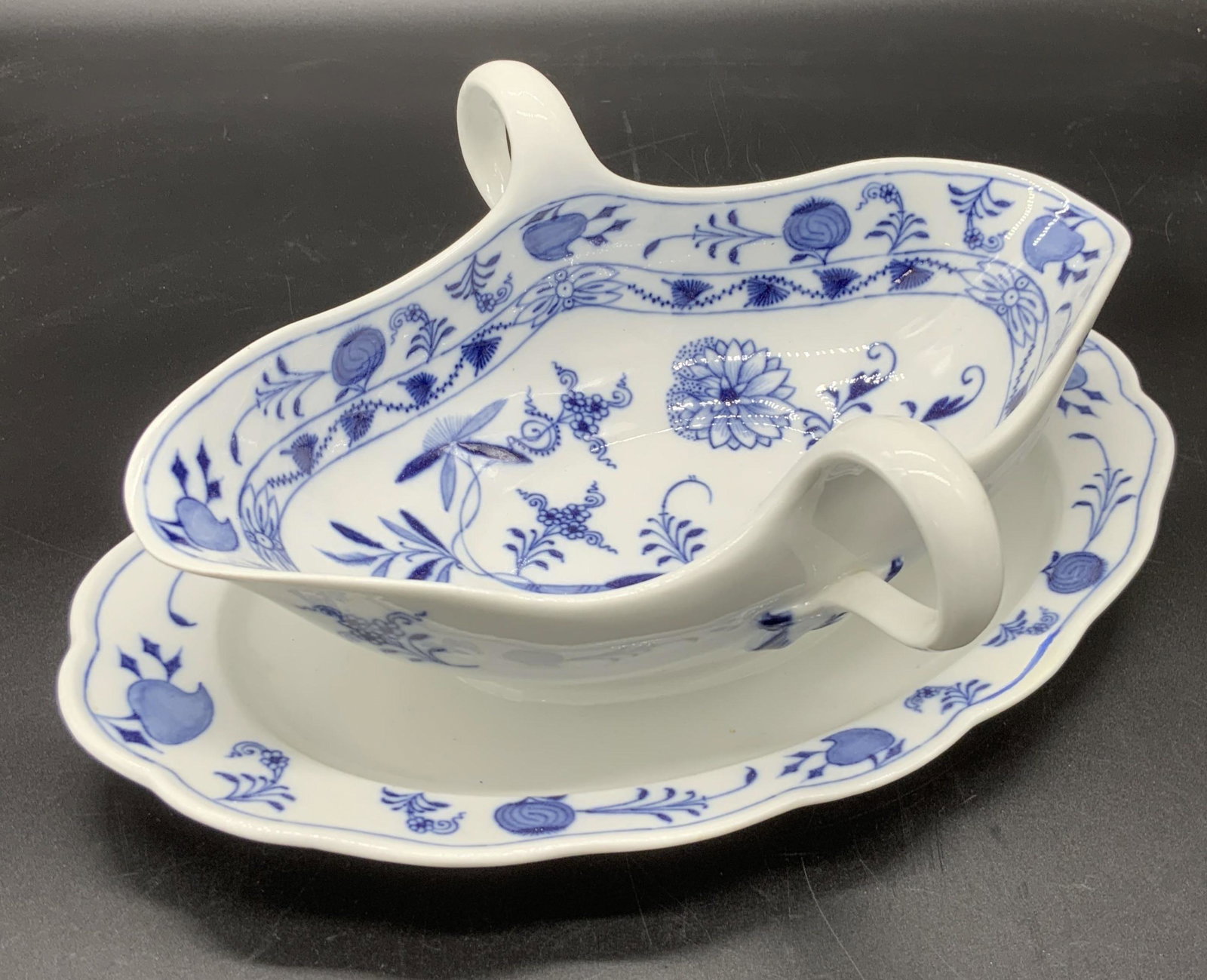 MEISSEN Signed Blue & White Porcelain Gravy Boat: Appears to be the blue onion pattern. A white porcelain gravy boat decorated with blue designs. The designs depict Classic Meissen florals and nature motifs. The piece features twin handles on either 